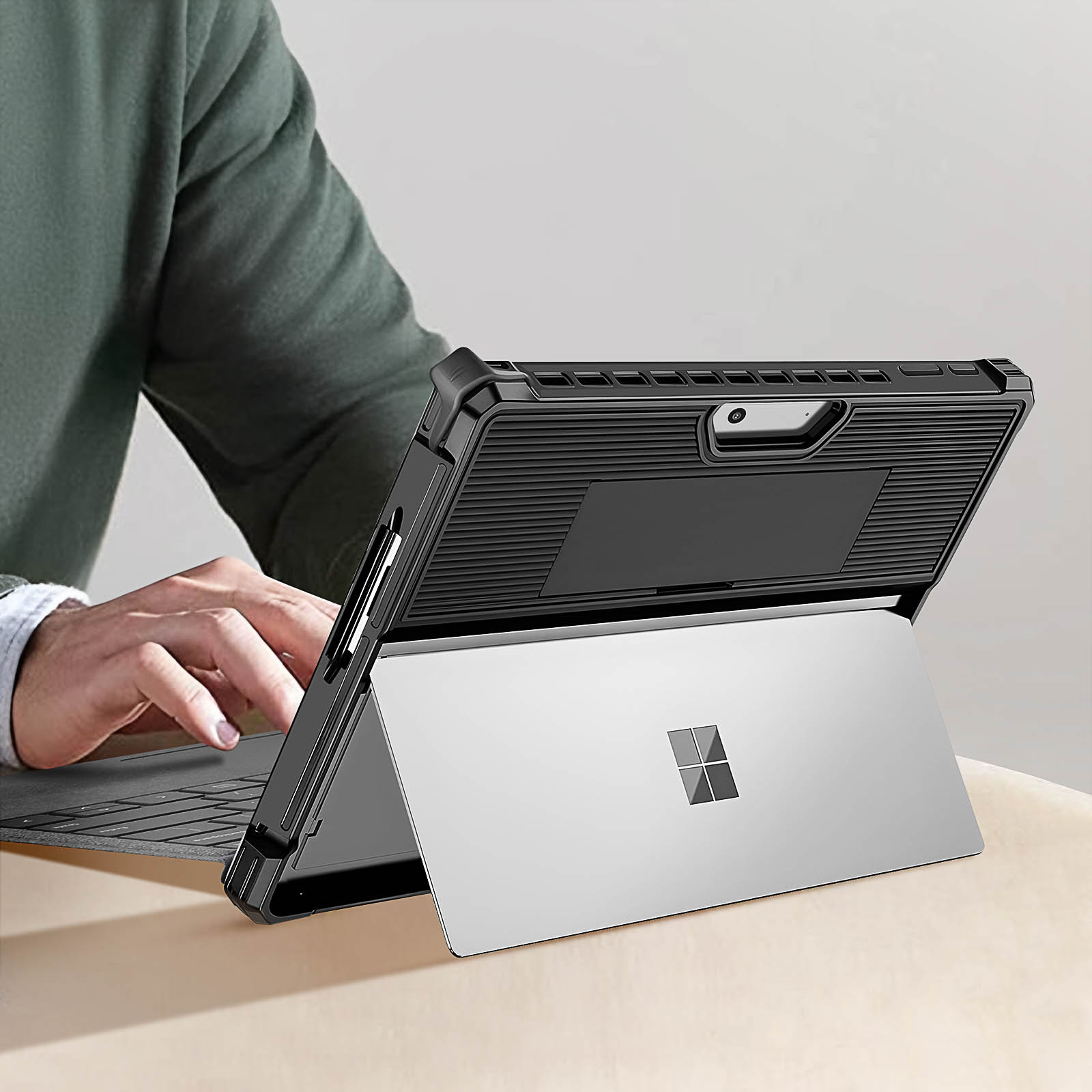 Una persona usa un laptop con una custodia protettiva. Il laptop è aperto su un tavolo.