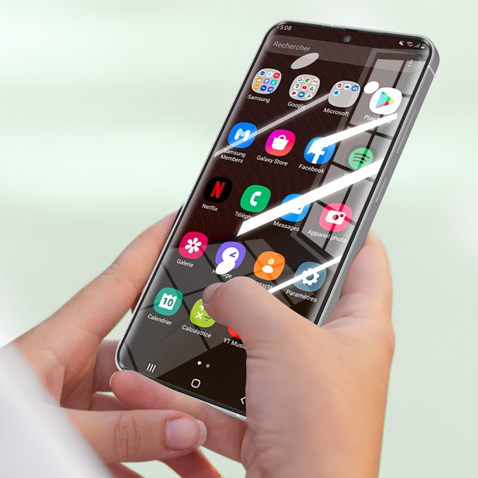 Mani che tengono uno smartphone argentato con app visibili sullo schermo.