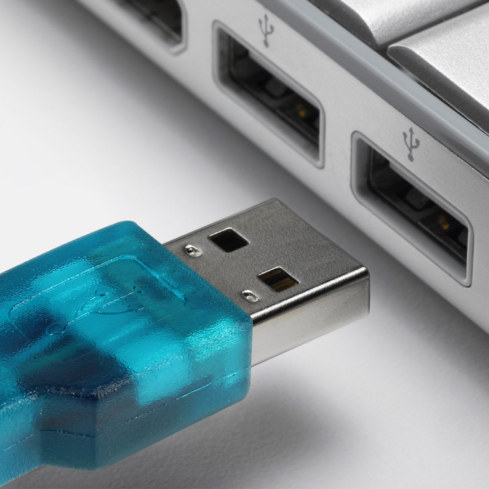 Cavo USB collegato a un computer. L'estremità USB è turchese. Il computer è argento.