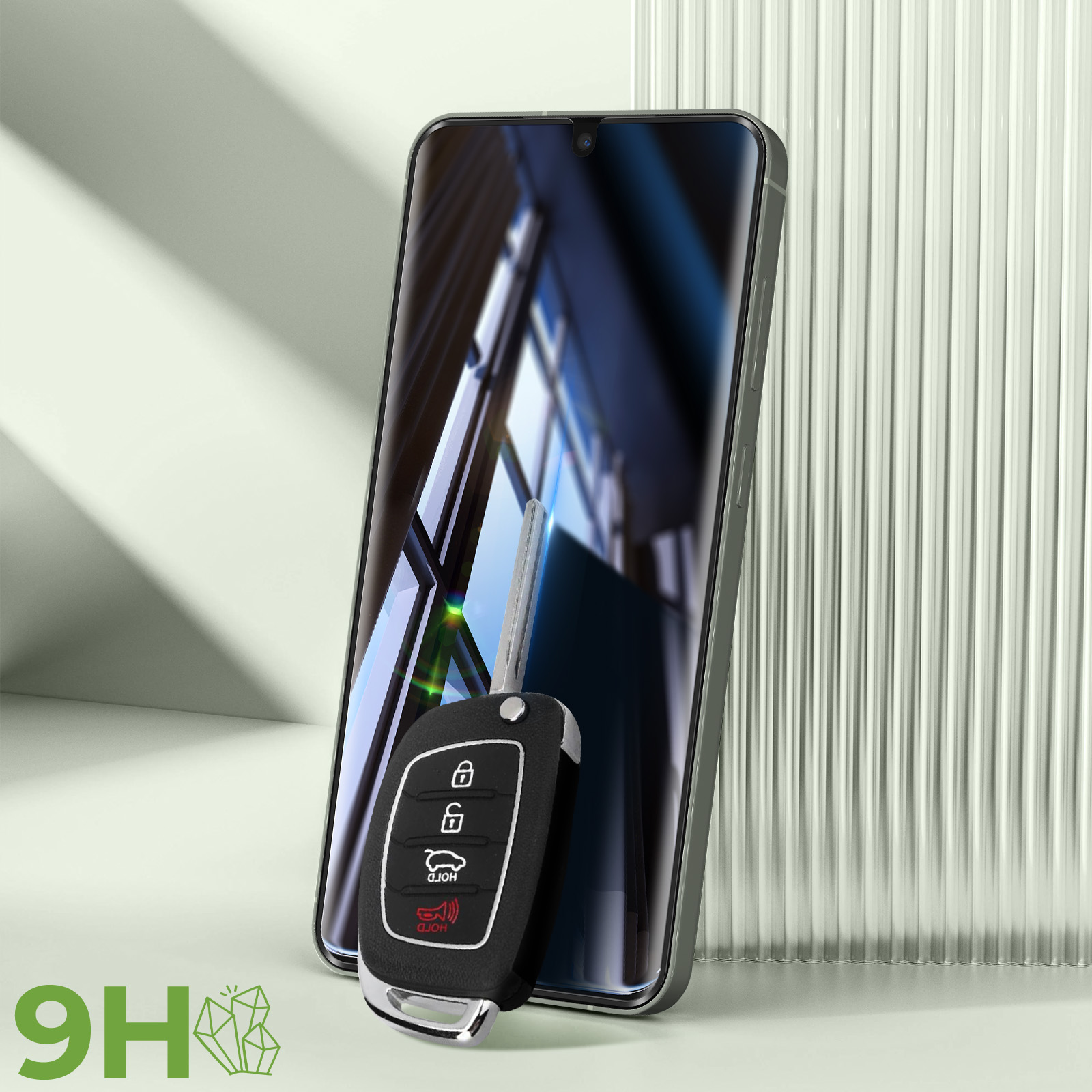 Una chiave per auto nera accanto a un telefono. Il telefono è appoggiato a uno sfondo a coste.