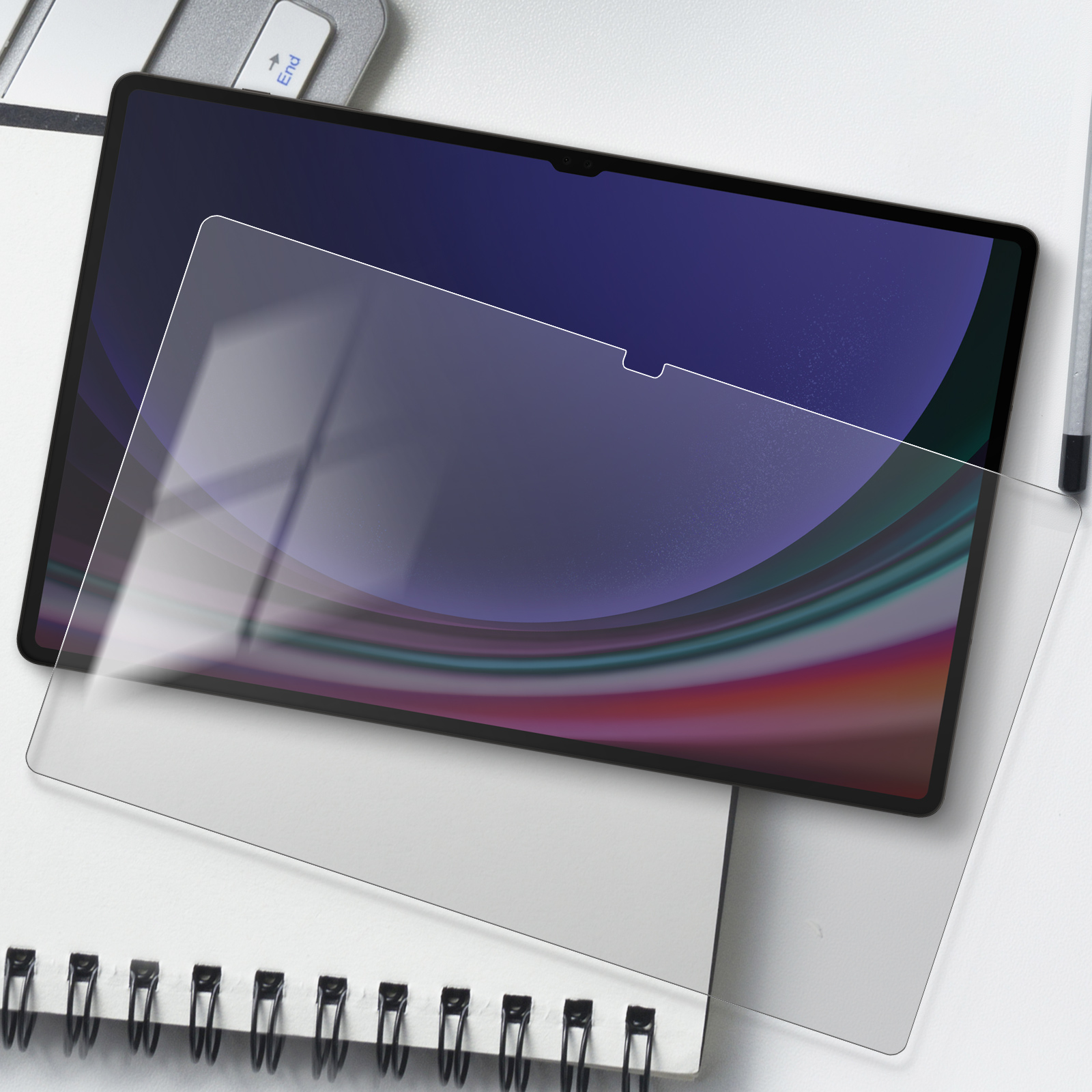 Tablet con protezione schermo parzialmente applicata. La protezione è trasparente e posizionata su una superficie.