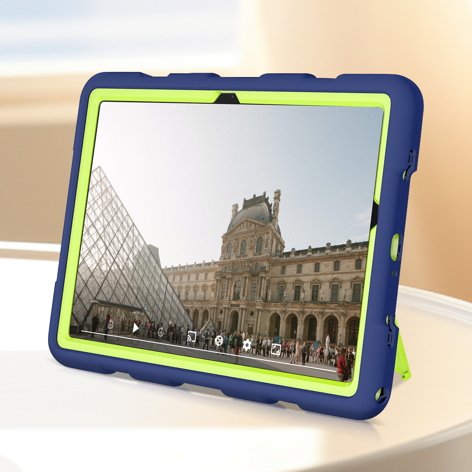 Ein Tablet in einer blau-grünen Hülle, das ein Video vom Louvre zeigt.