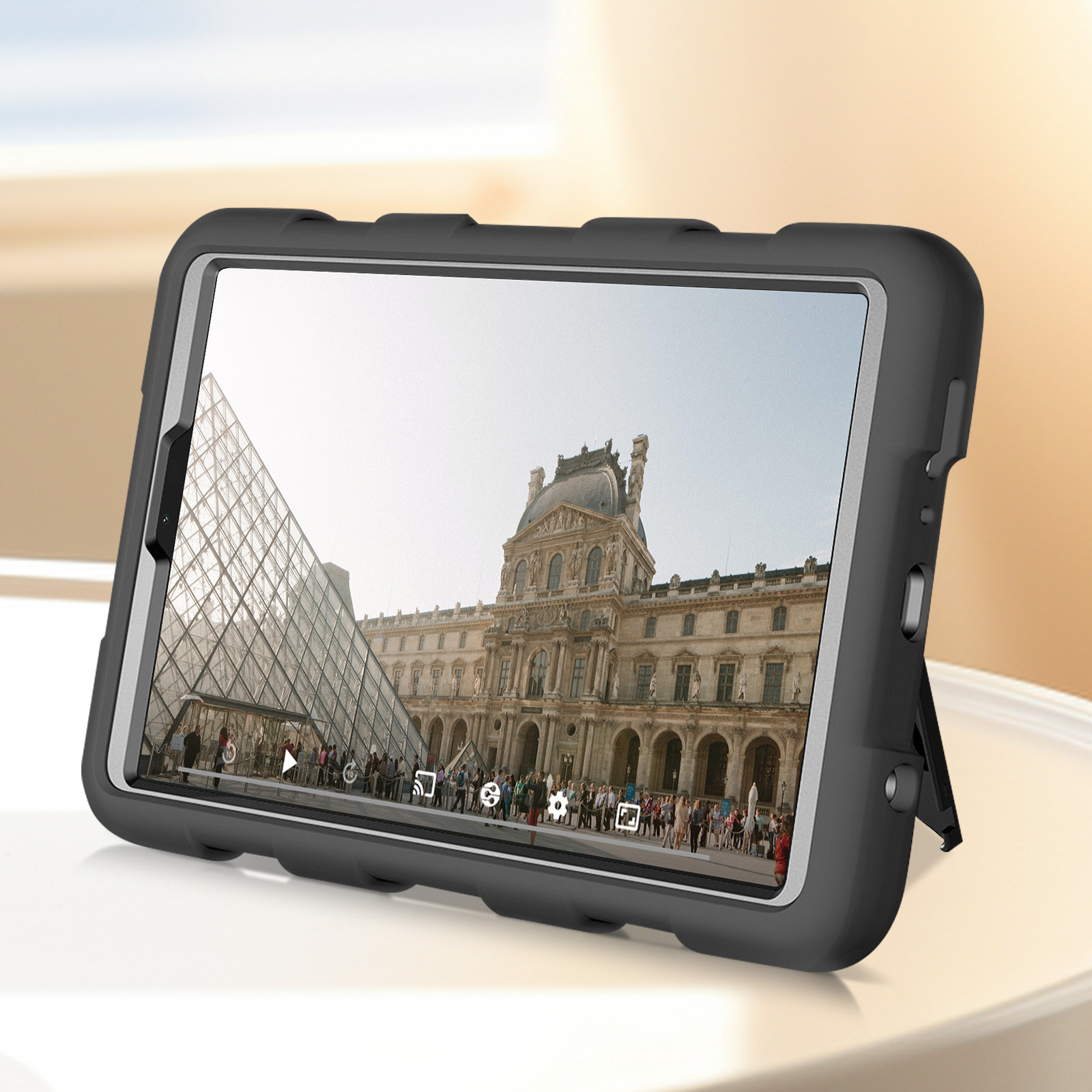 Tablet in schwarzem Gehäuse, zeigt Gebäude mit Menschen. Ein Ständer stützt das Gerät.