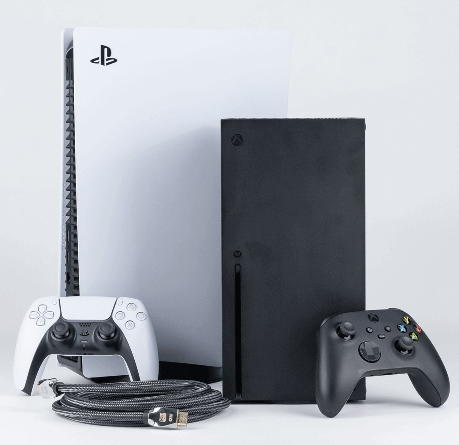 Konsole do gier: białe PlayStation 5, czarne Xbox Series X, kontrolery i kabel.