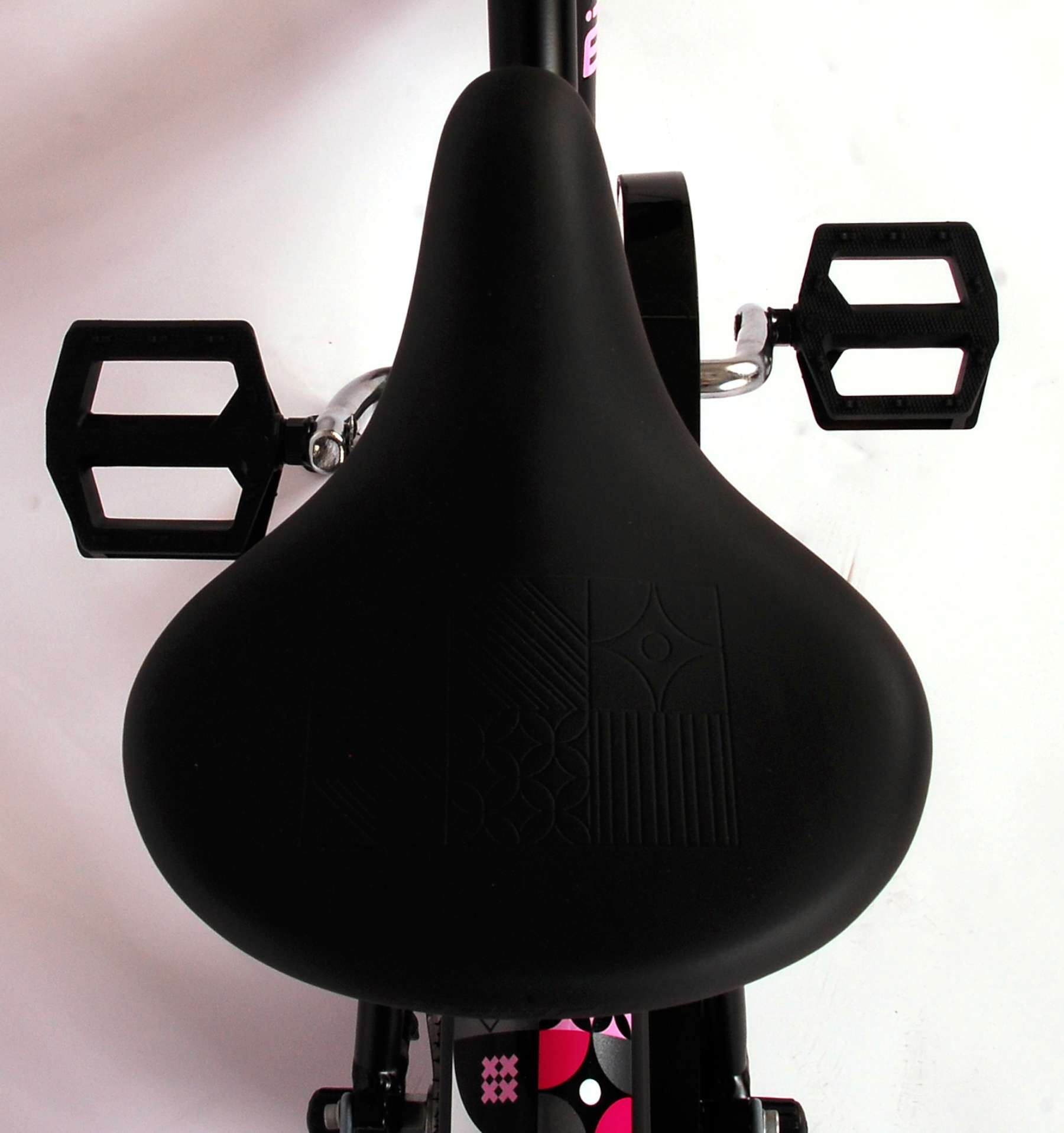 Schwarzer Fahrradsattel mit Pedalen. Der Sattel befindet sich auf einem schwarzen Fahrradrahmen.