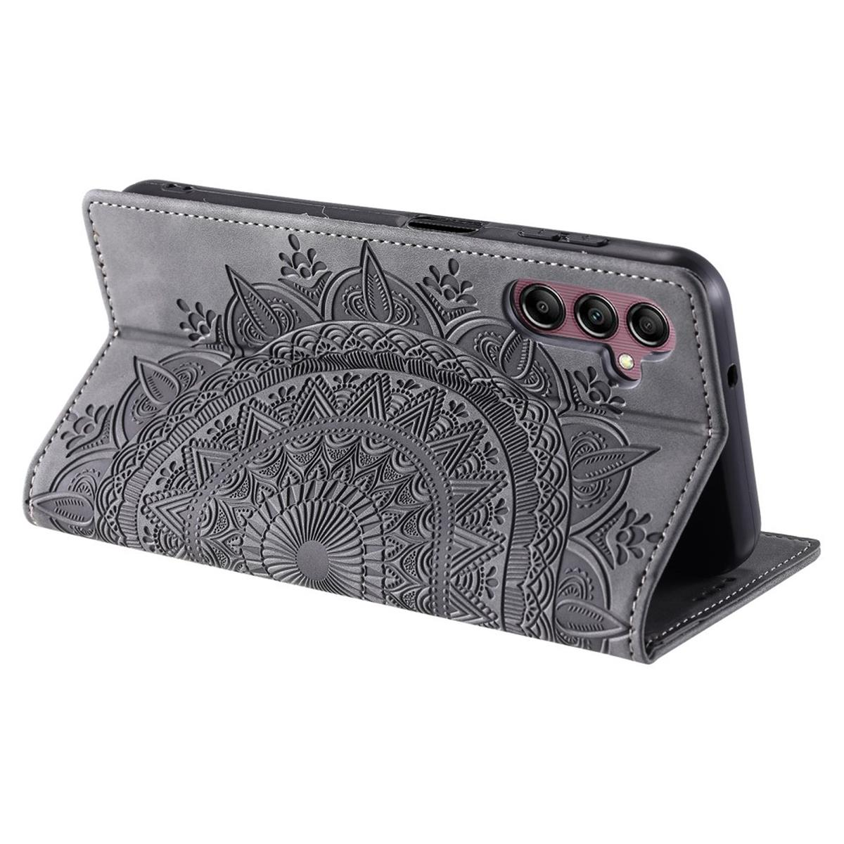 Eine graue Handyhülle mit geprägtem Mandala-Design, geöffnet, um das Telefon zu zeigen.