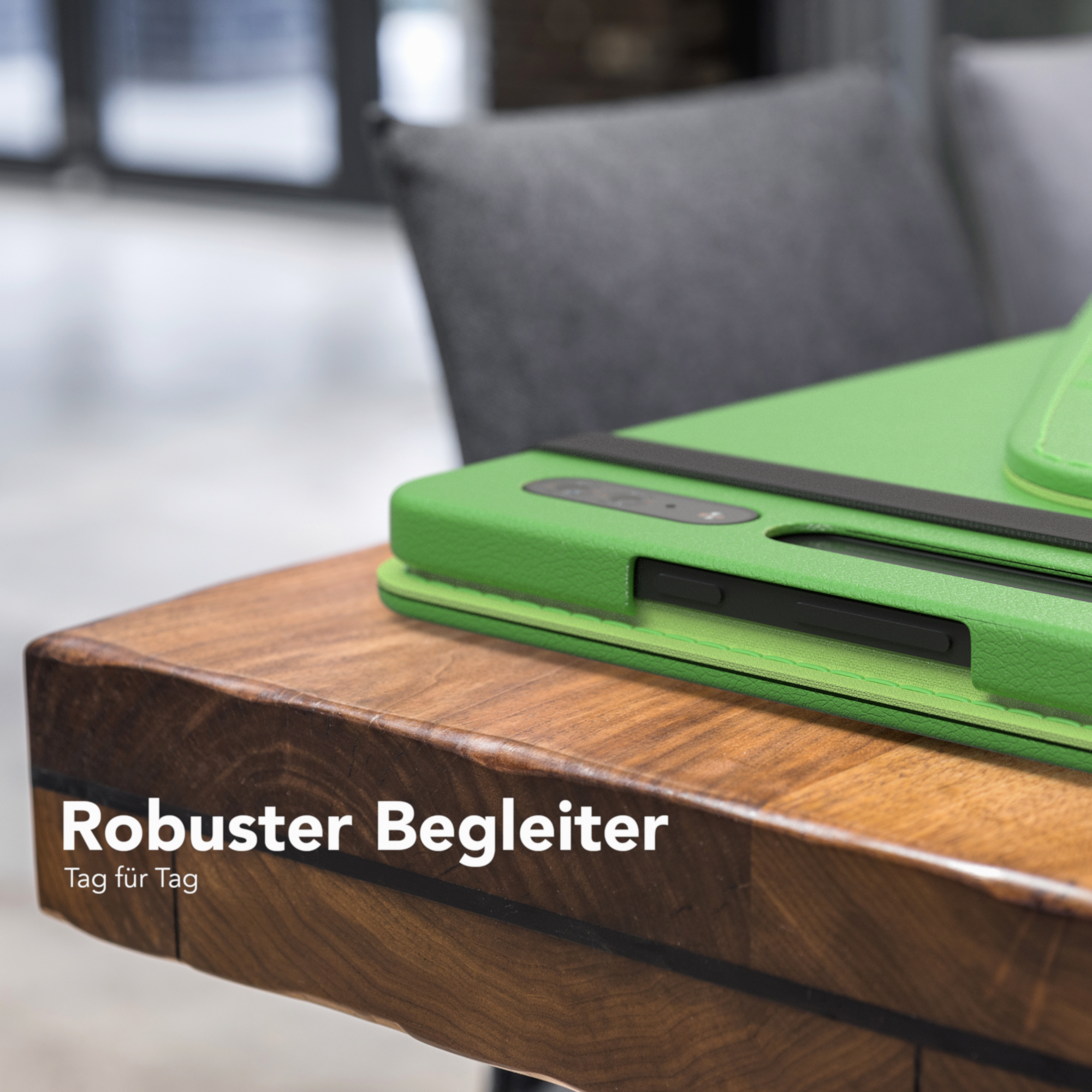 Grüne Handyhülle auf einem Holztisch. Text: „Robuster Begleiter“ und „Tag für Tag“.