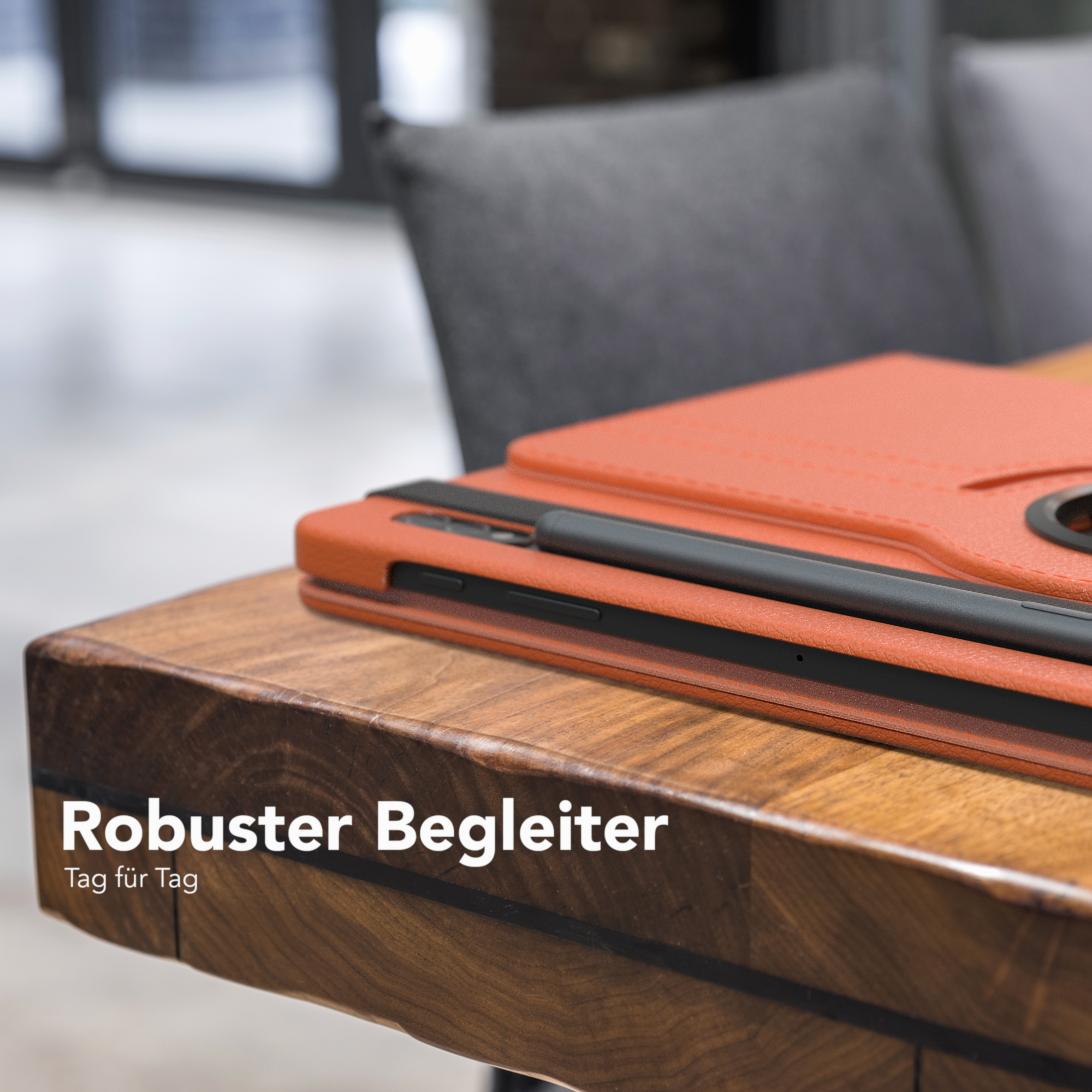 Tablet in einer orangen Hülle auf einem Holztisch. Text: 'Robuster Begleiter'.