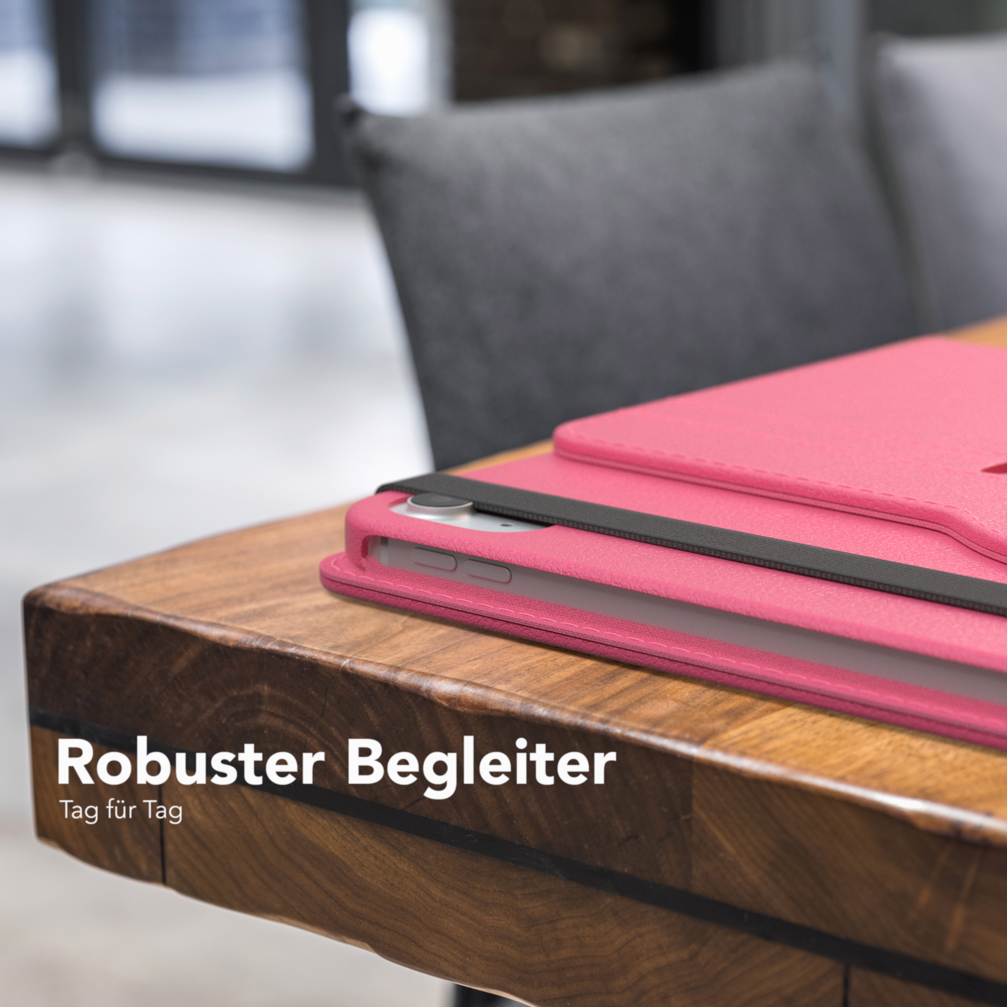 Eine rosa Tablet-Hülle auf einem Holztisch. Der Text lautet 'Robuster Begleiter'.
