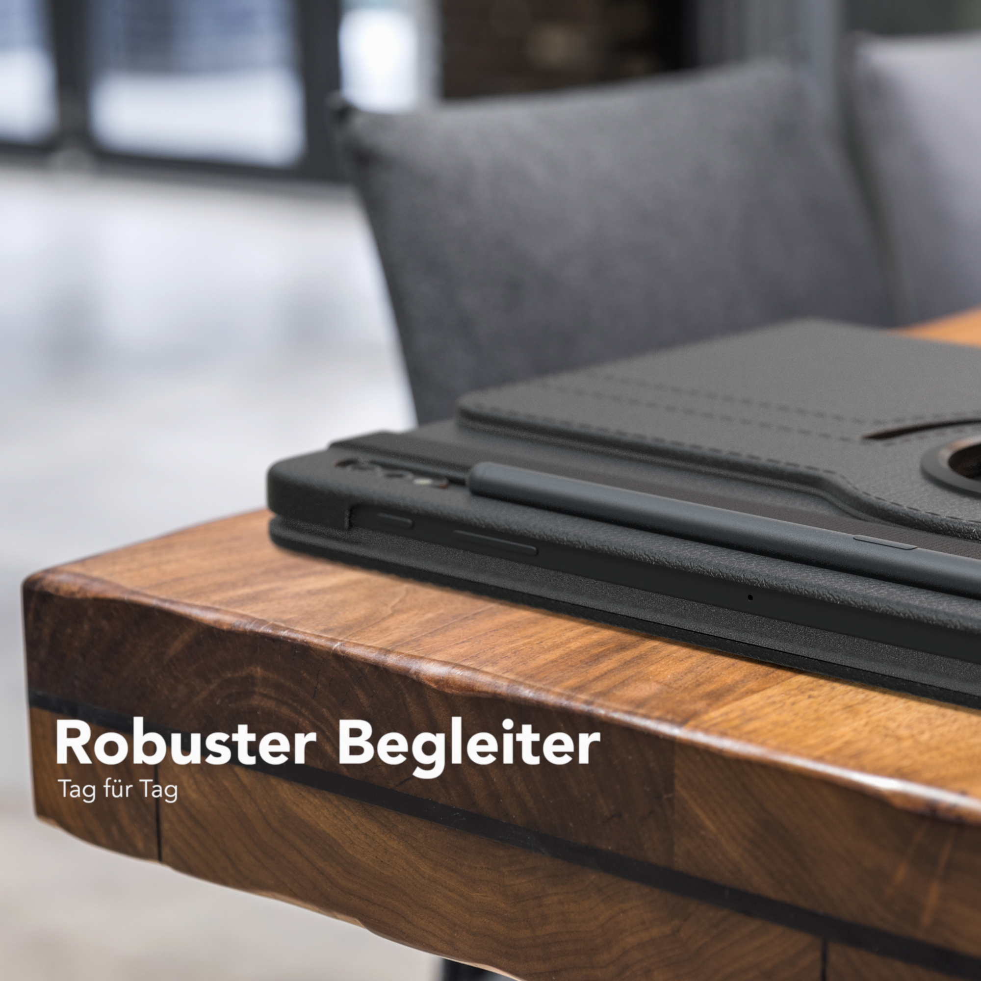 Tablet und Stift auf einem Holztisch. Der Text auf dem Tisch lautet 'Robuster Begleiter'.