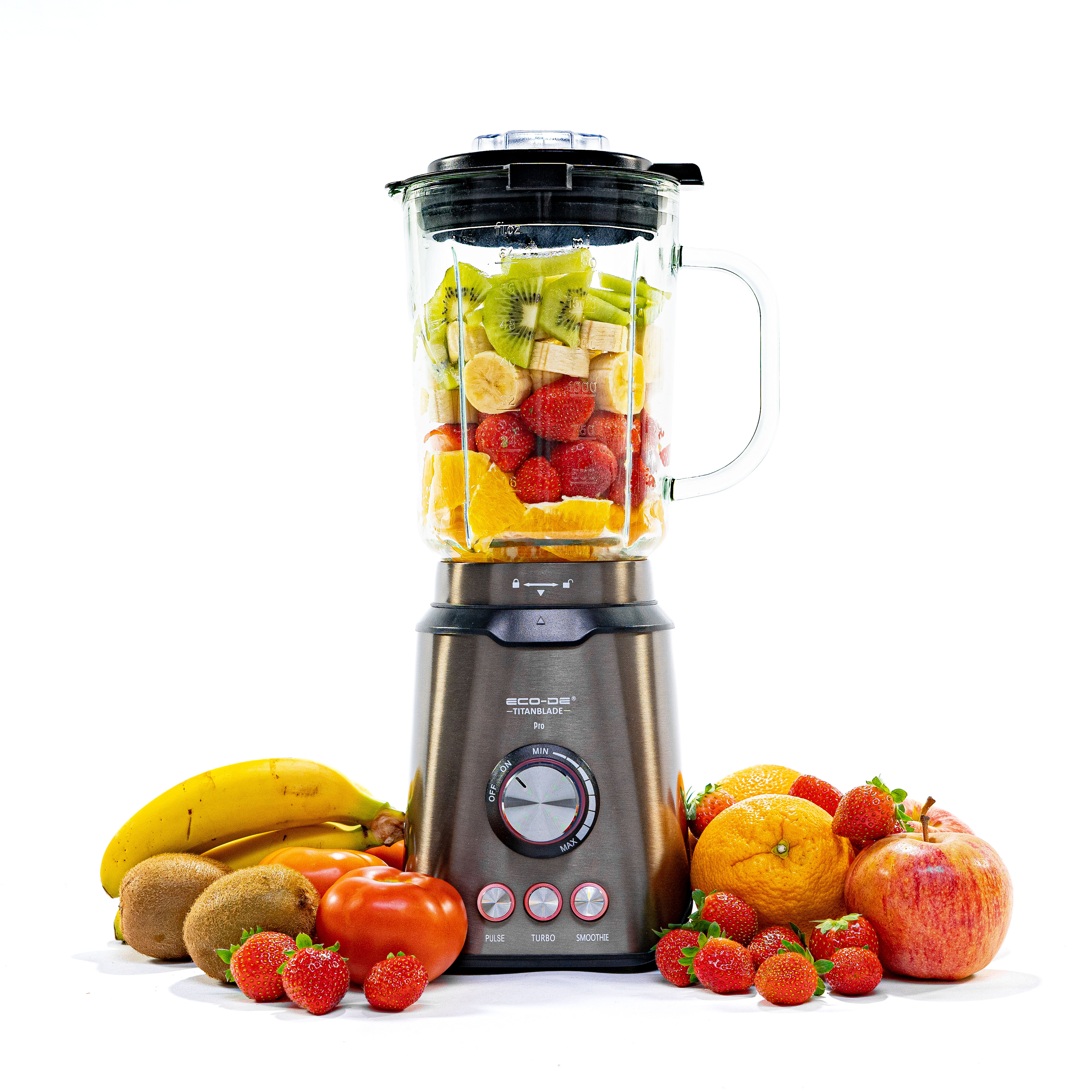 Licuadora con frutas dentro y una variedad de frutas dispuestas alrededor.