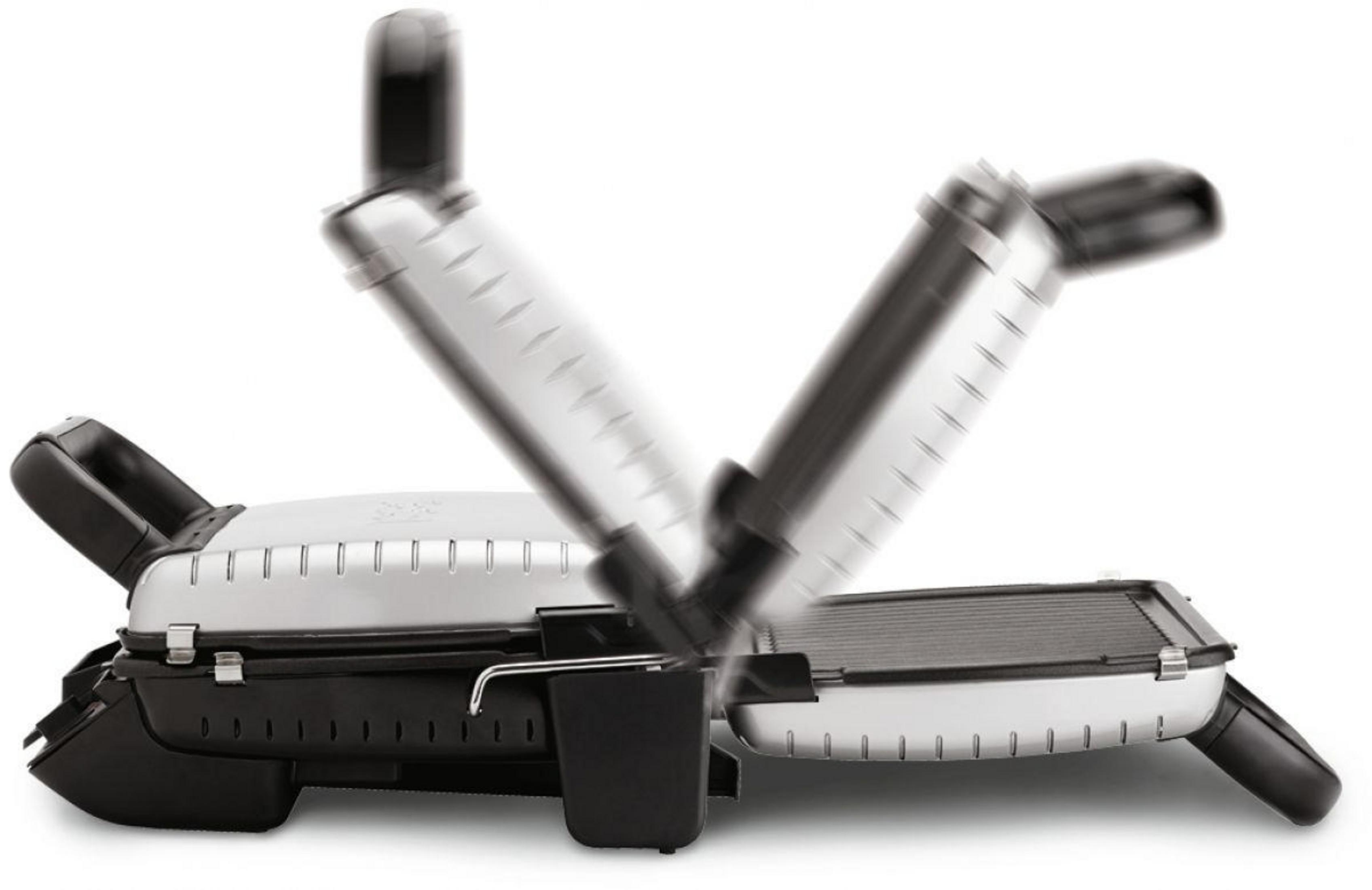 Grill z dwiema otwartymi częściami. Srebrny i czarny. Widoczne ruszty i uchwyty.