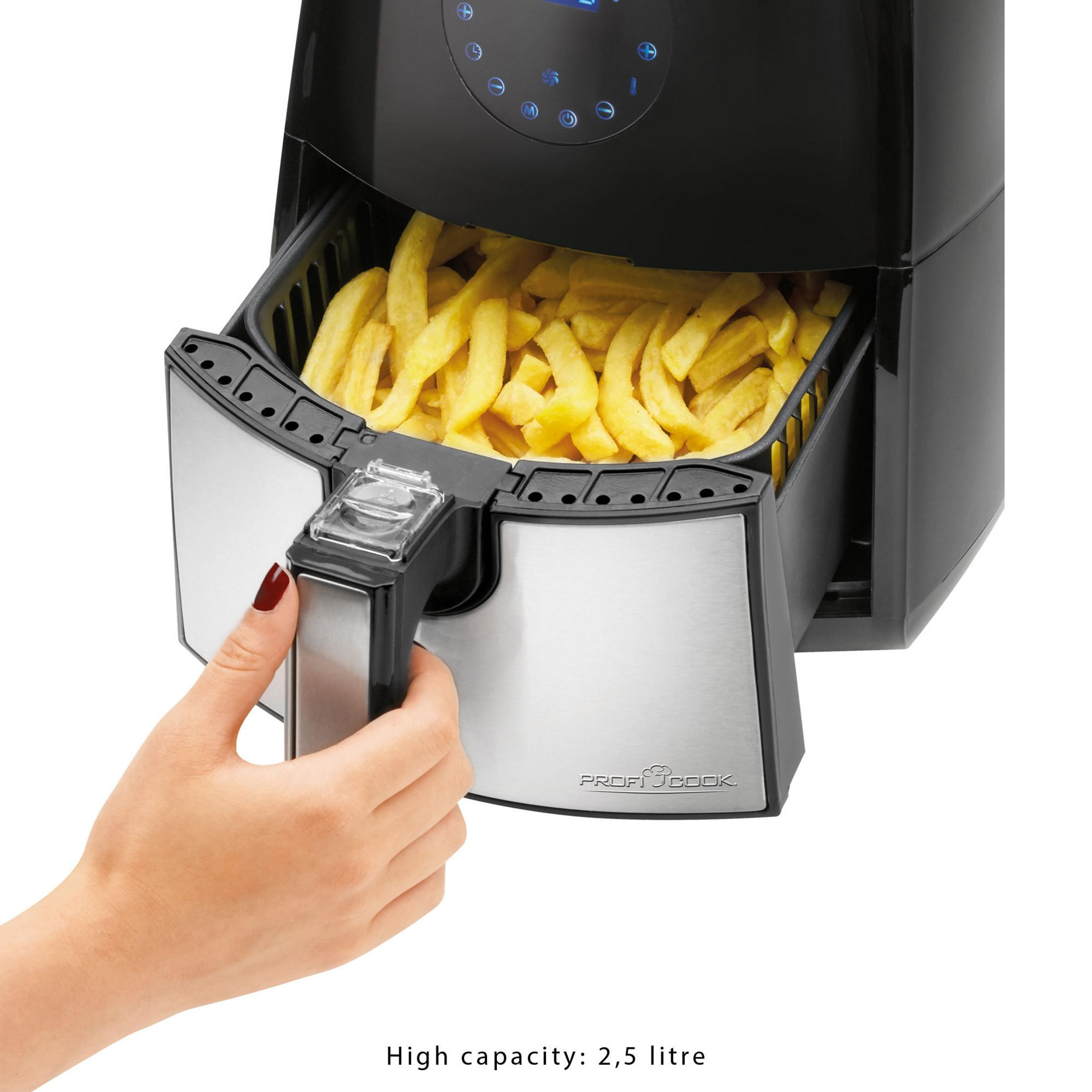Frytownica powietrzna z frytkami w środku i dłoń sięgająca po uchwyt.
