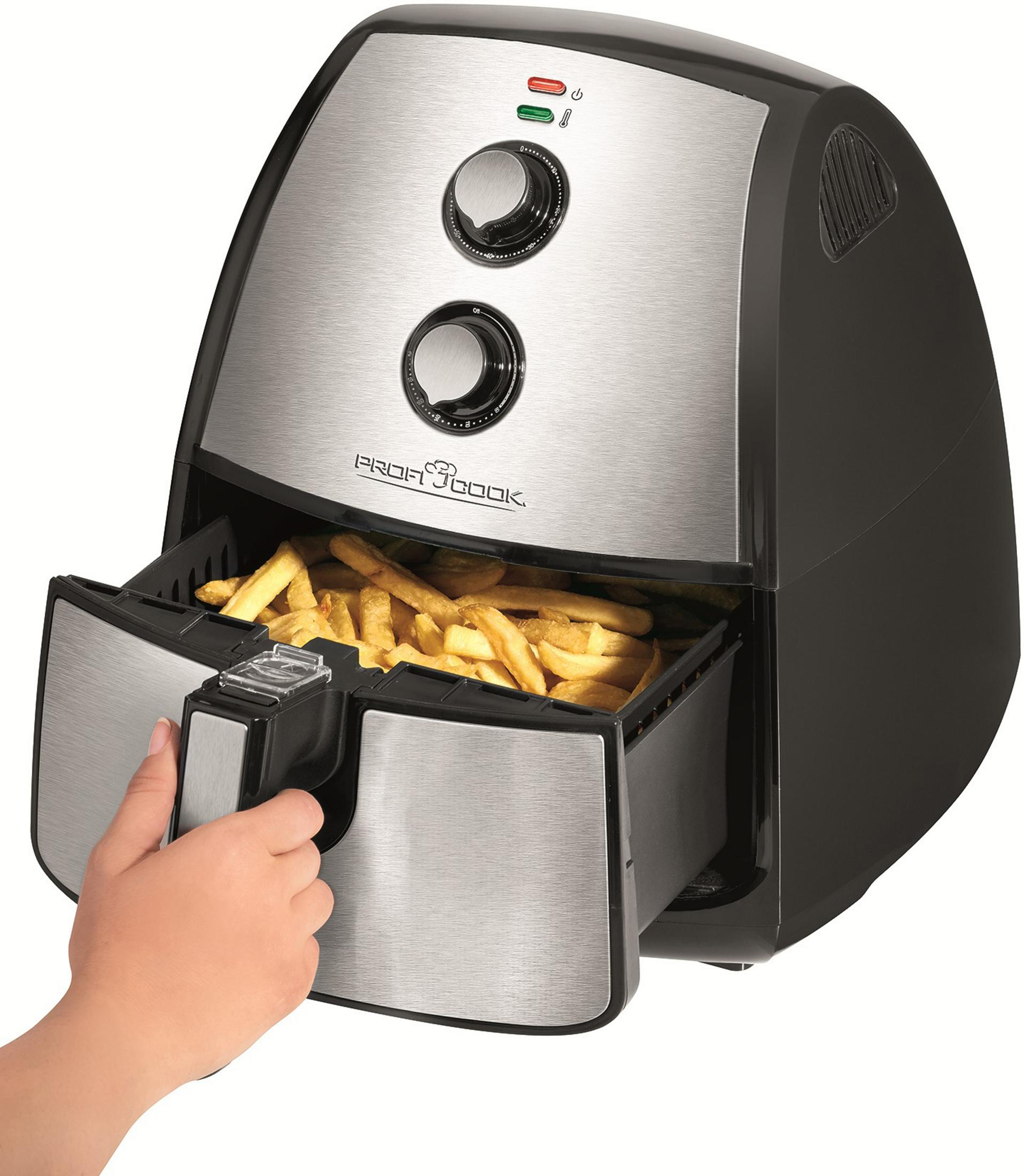 Une friteuse à air avec une main qui sort le panier rempli de frites.