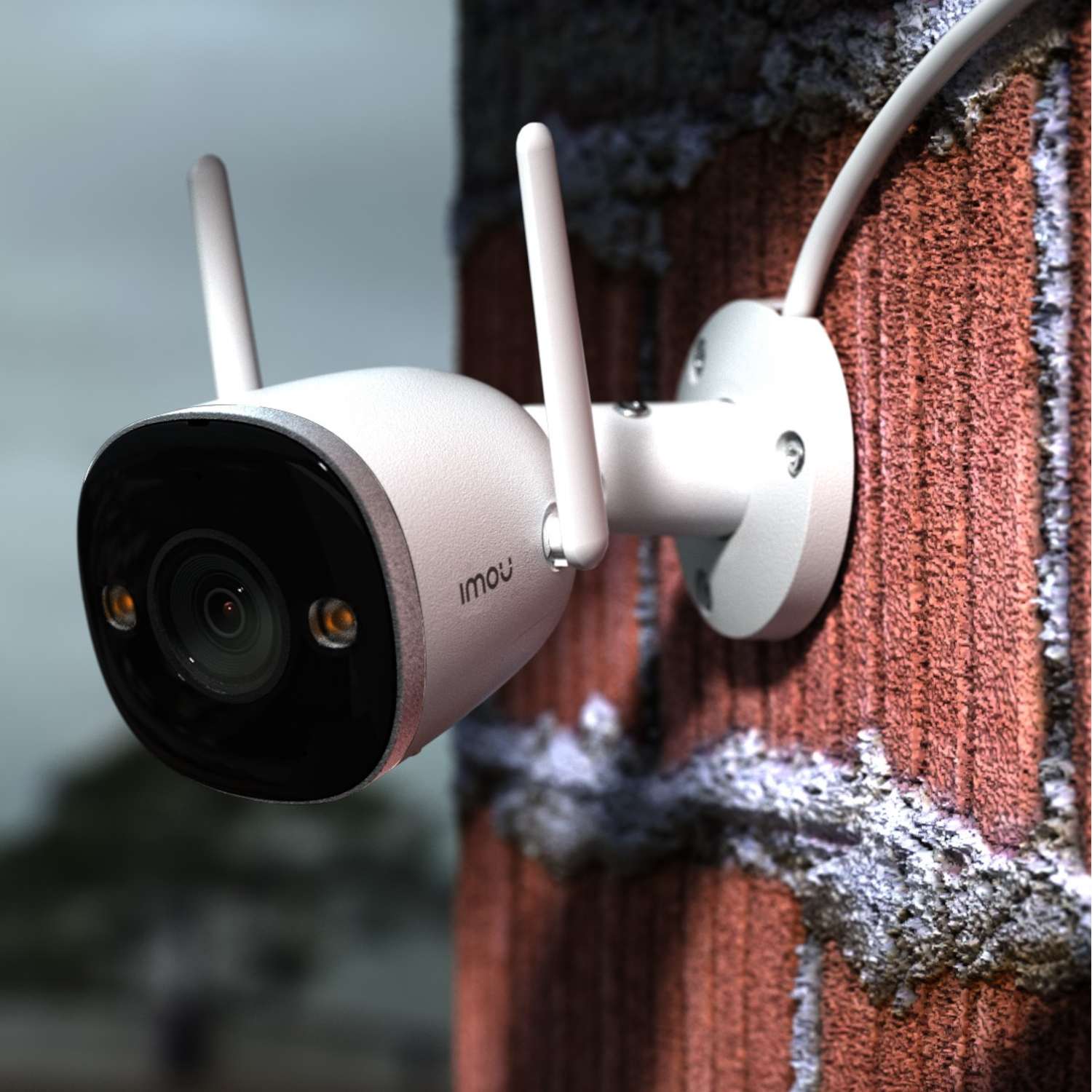 Een witte beveiligingscamera gemonteerd op een bakstenen muur. Twee antennes wijzen omhoog.