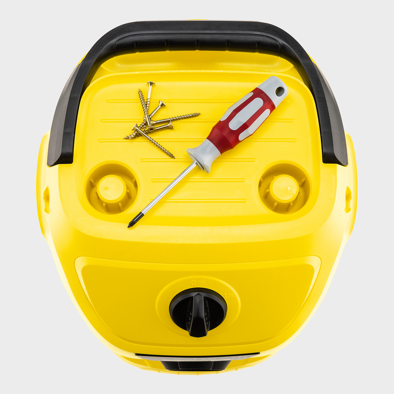 Żółta góra od odkurzacza ze śrubami i śrubokrętem. Czarny uchwyt i włącznik.