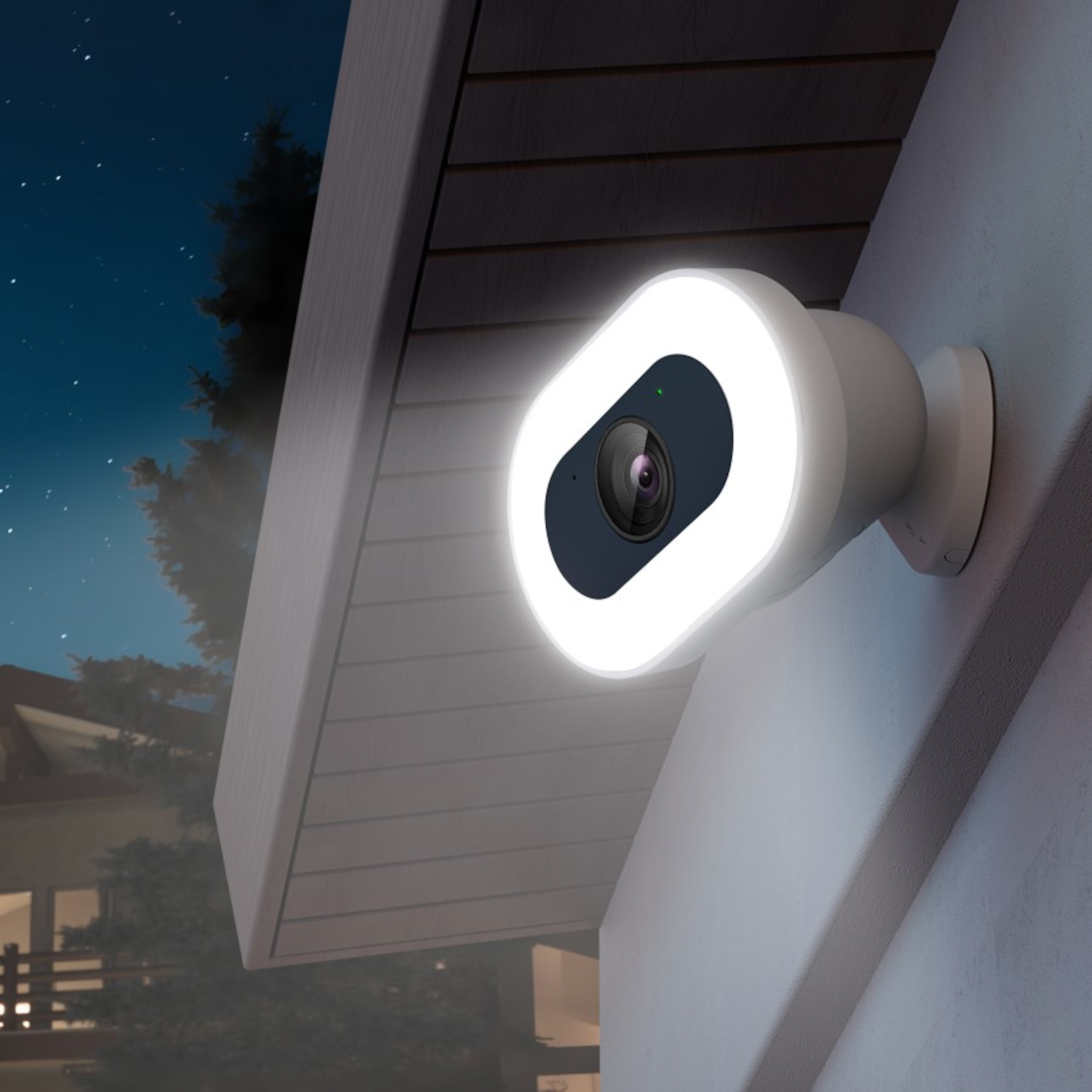 Kamera bezpieczeństwa na ścianie, oświetlona białym światłem w nocy.