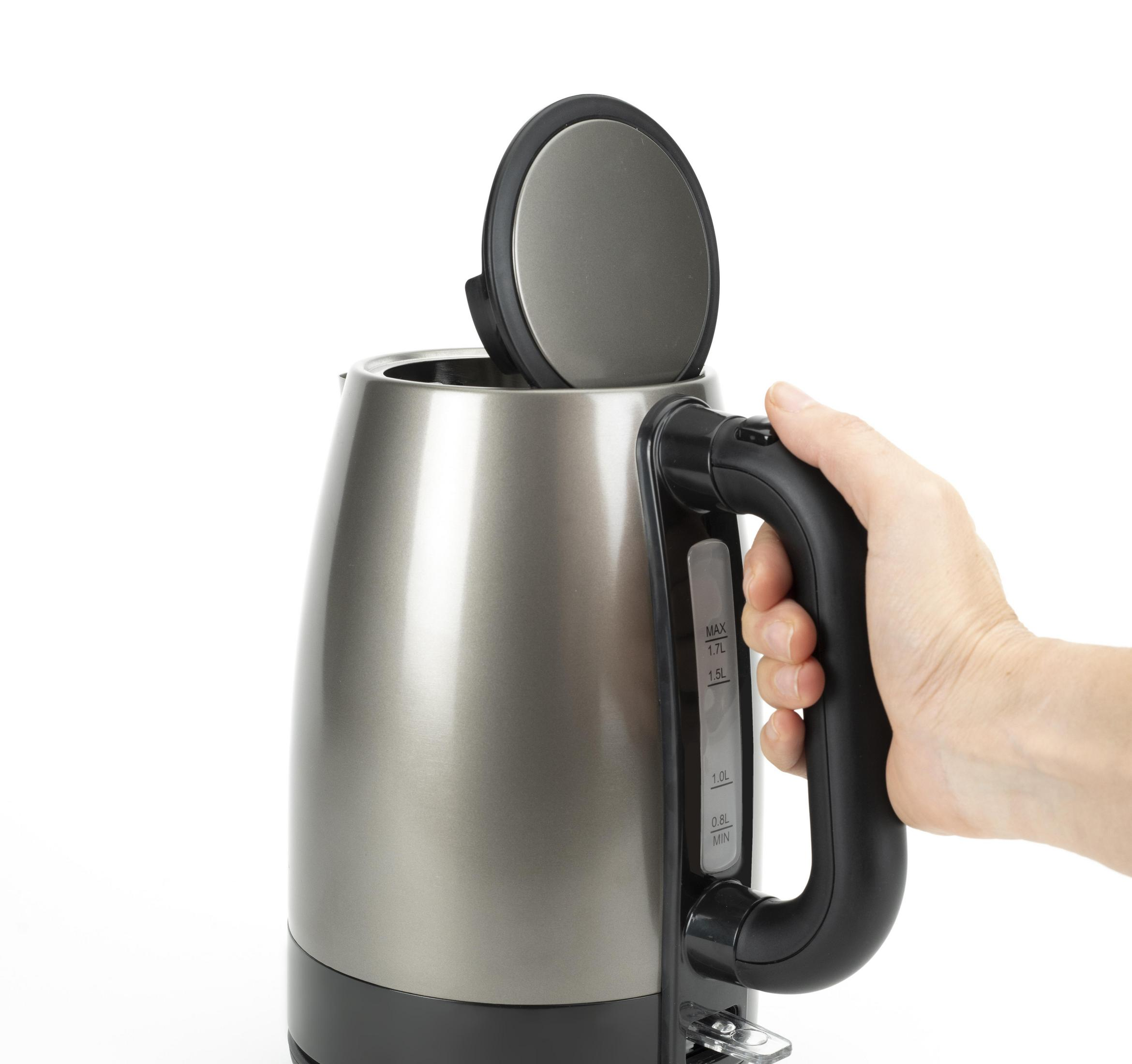 Dłoń trzymająca metaliczny, szary czajnik elektryczny z otwartą pokrywą.
