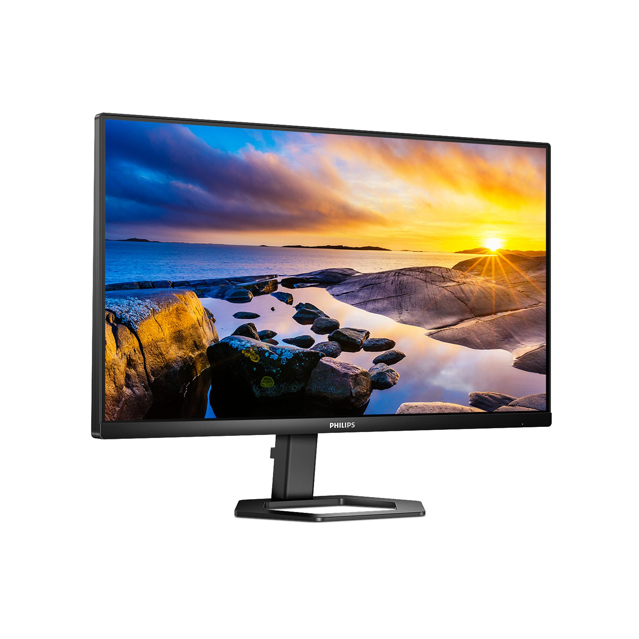 Un monitor di computer mostra un tramonto sul mare e la costa rocciosa.