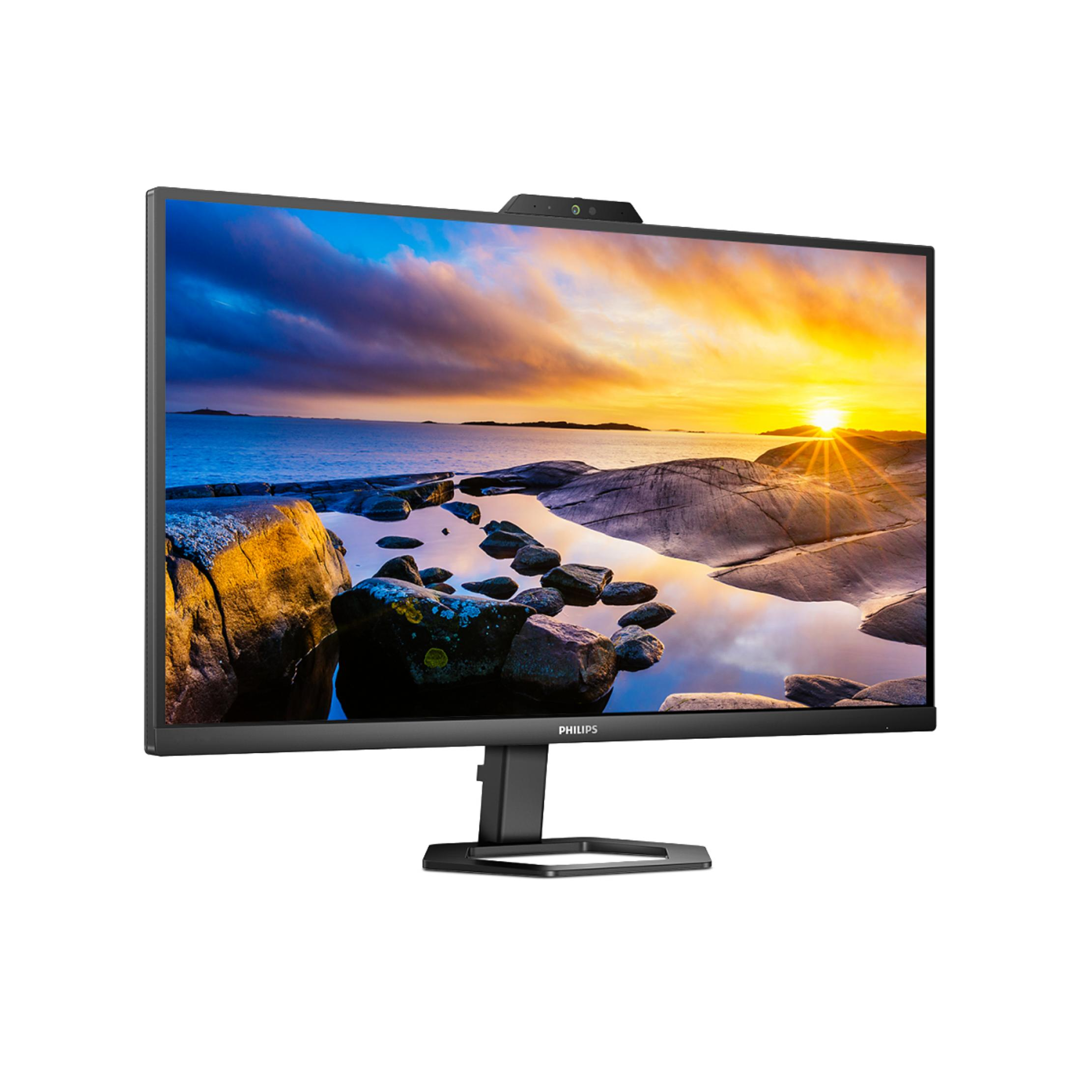 A large computer monitor with a webcam on top, showing a sunset scene on the screen.