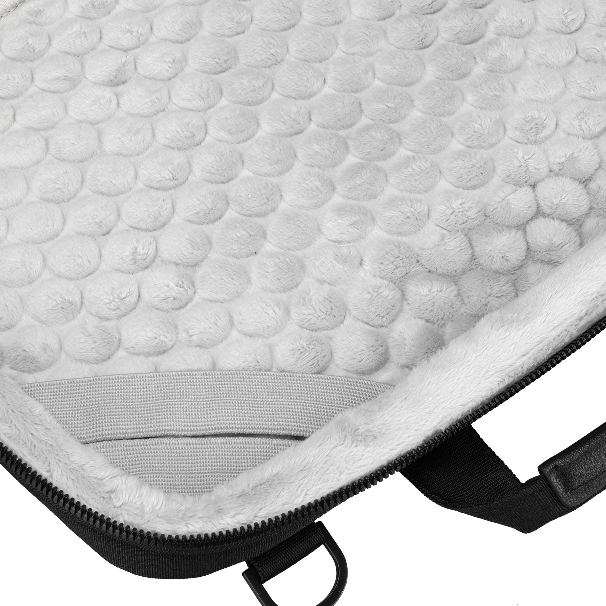 All'interno di una custodia nera per laptop. Materiale bianco e soffice riveste l'interno. Una cerniera nera è visibile.