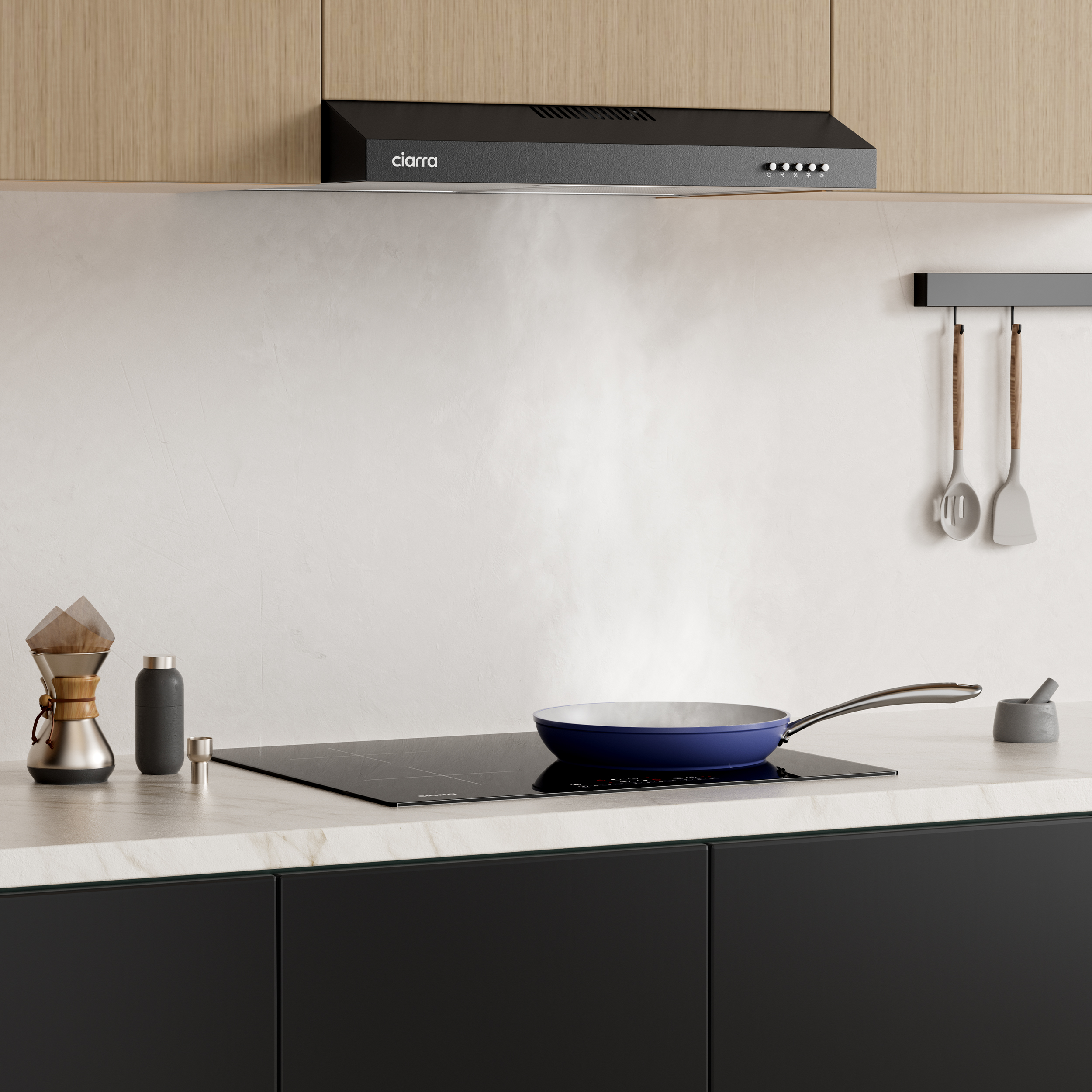 Keuken met een zwart fornuis, blauwe pan en afzuigkap met het label 'ciarra'.