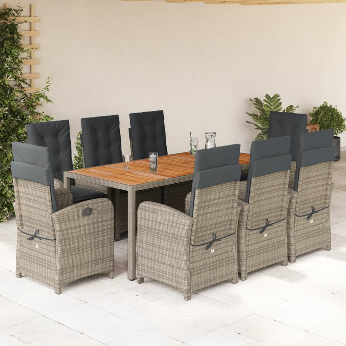 Essgruppe im Freien: Holztisch, 8 Stühle mit grauen Kissen. Weißer Wandhintergrund. Sonniger Tag.