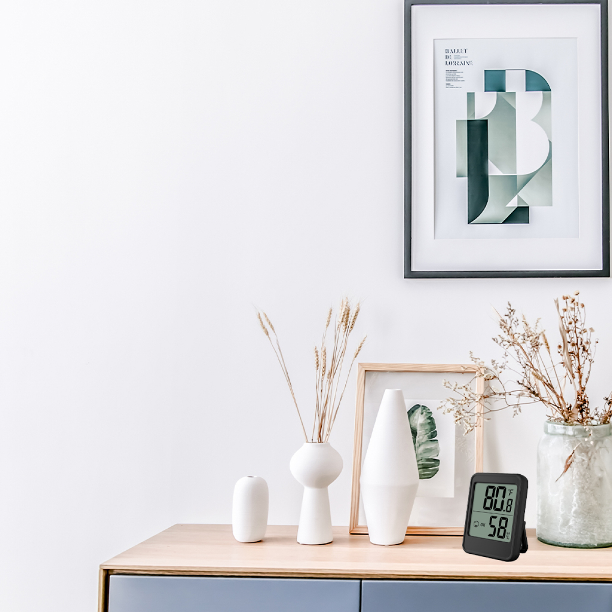 Ein Tisch mit Dekorationen, ein digitales Thermometer zeigt Zeit und Temperatur.