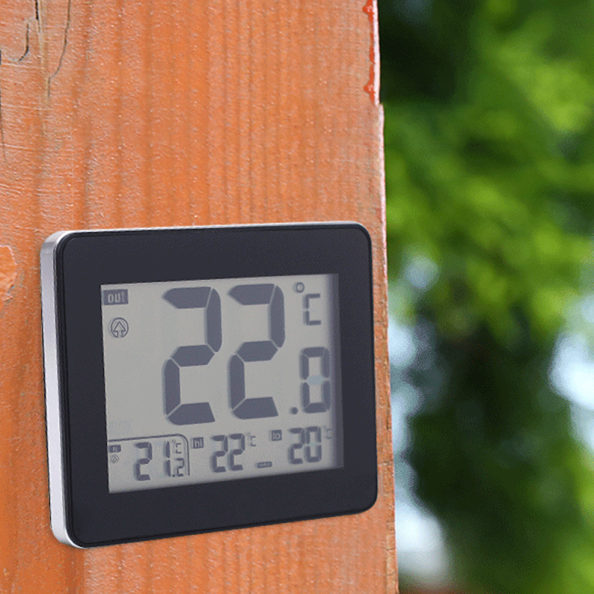 Digitales Thermometer, das 22,0 Grad Celsius anzeigt, an einem Holzpfosten montiert.