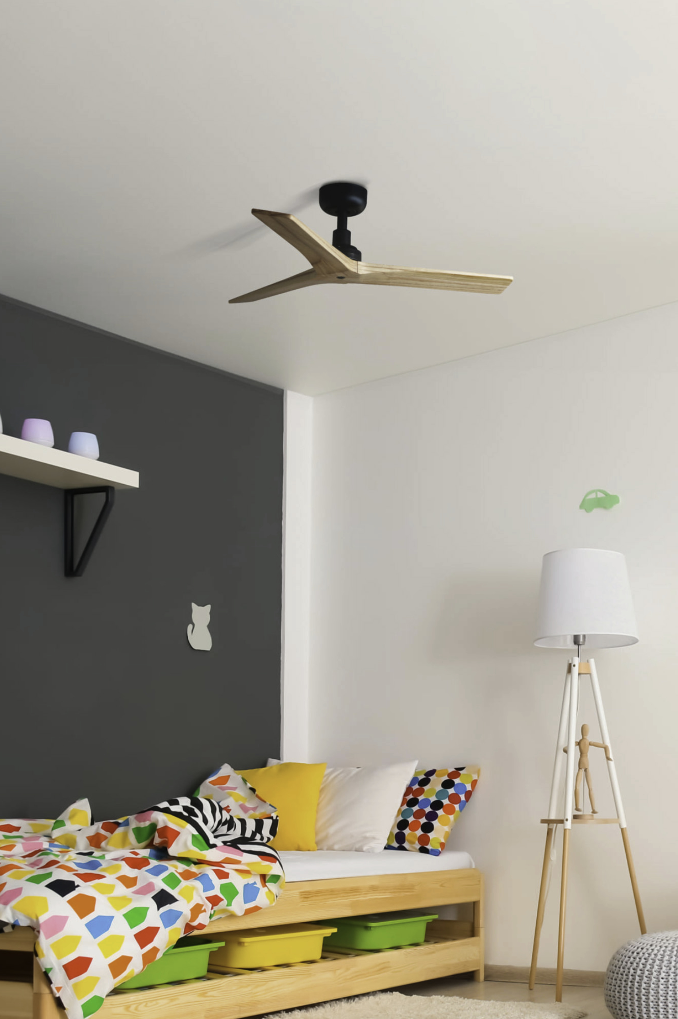 Una camera da letto con un ventilatore a soffitto e un letto con una coperta colorata.