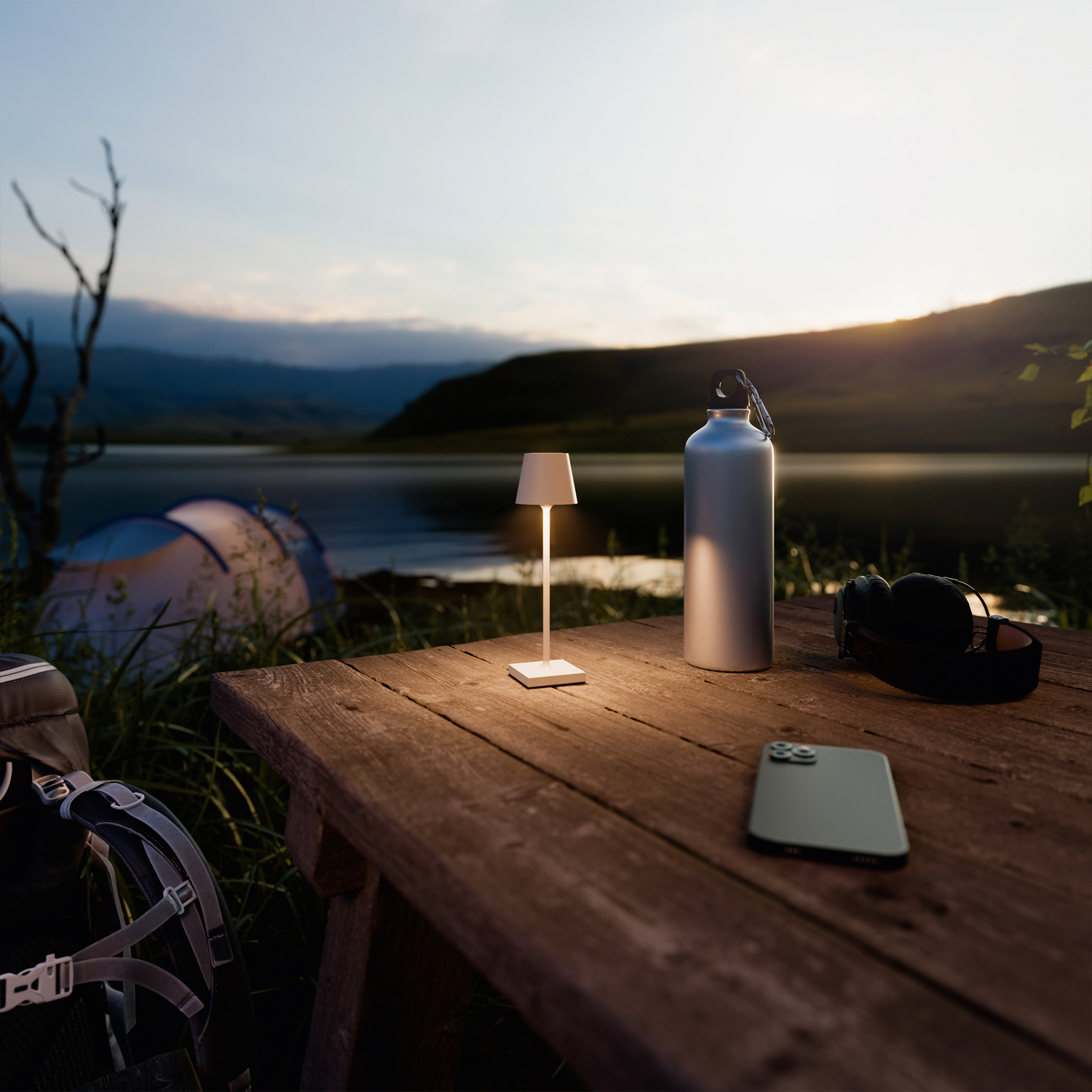 Tisch mit Lampe, Wasserflasche, Telefon und Kopfhörern am See.