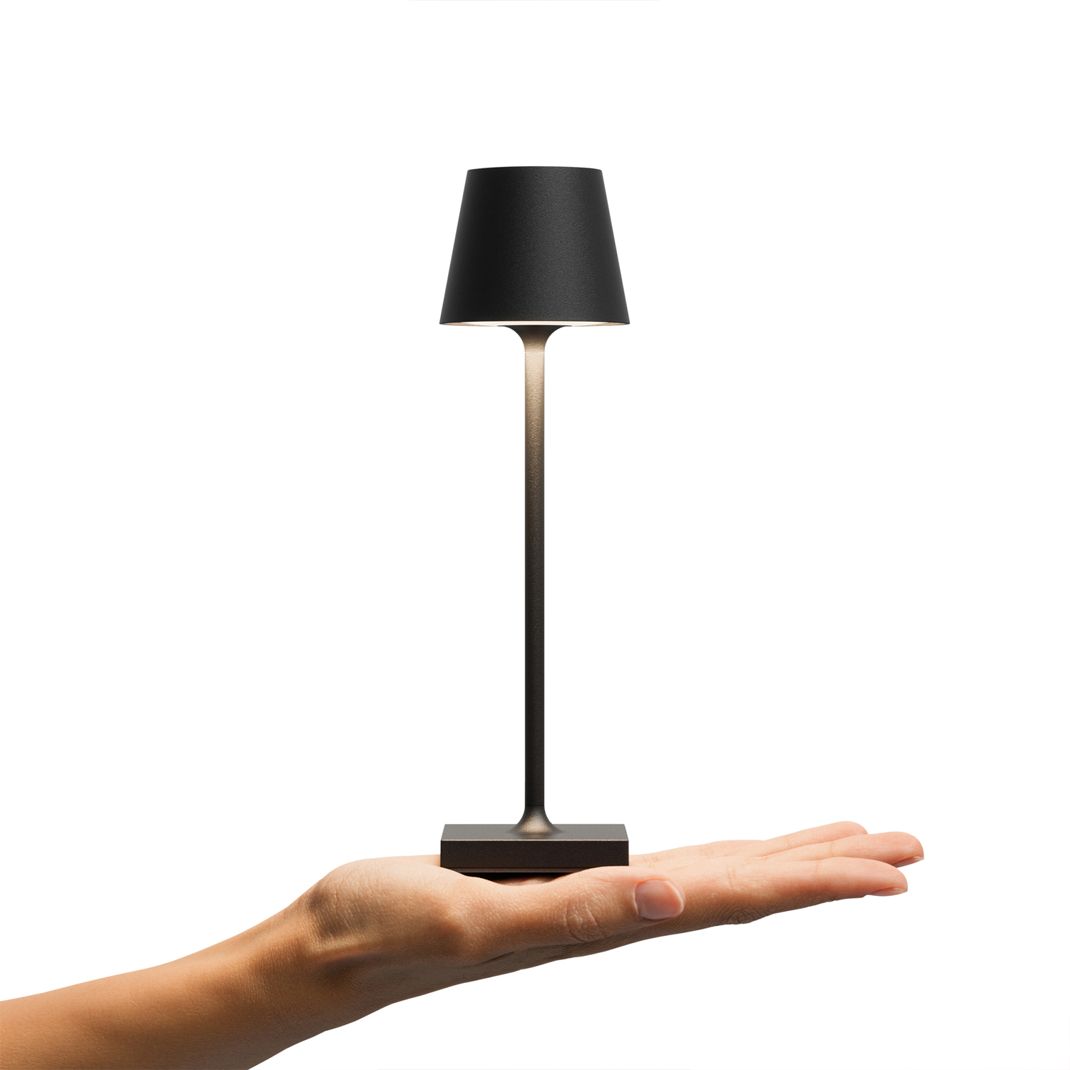 Eine kleine schwarze Lampe mit Lampenschirm, gehalten von einer Hand auf weißem Hintergrund.