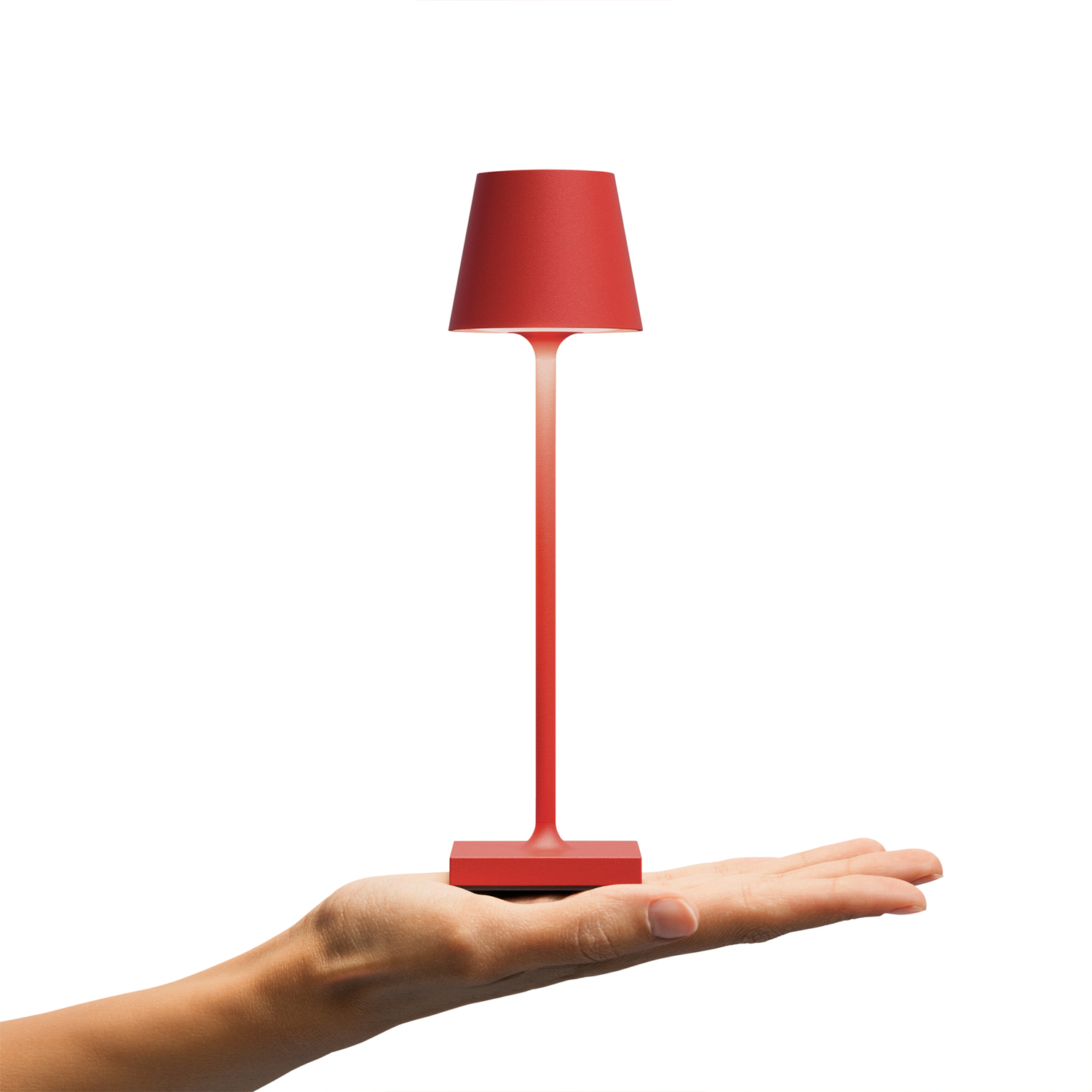 Rote Tischlampe, gehalten von einer Hand, weißer Hintergrund.