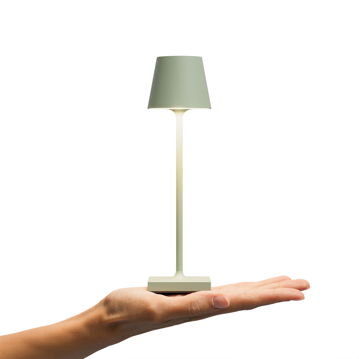 Eine Hand, die eine grüne Lampe vor weißem Hintergrund hält.
