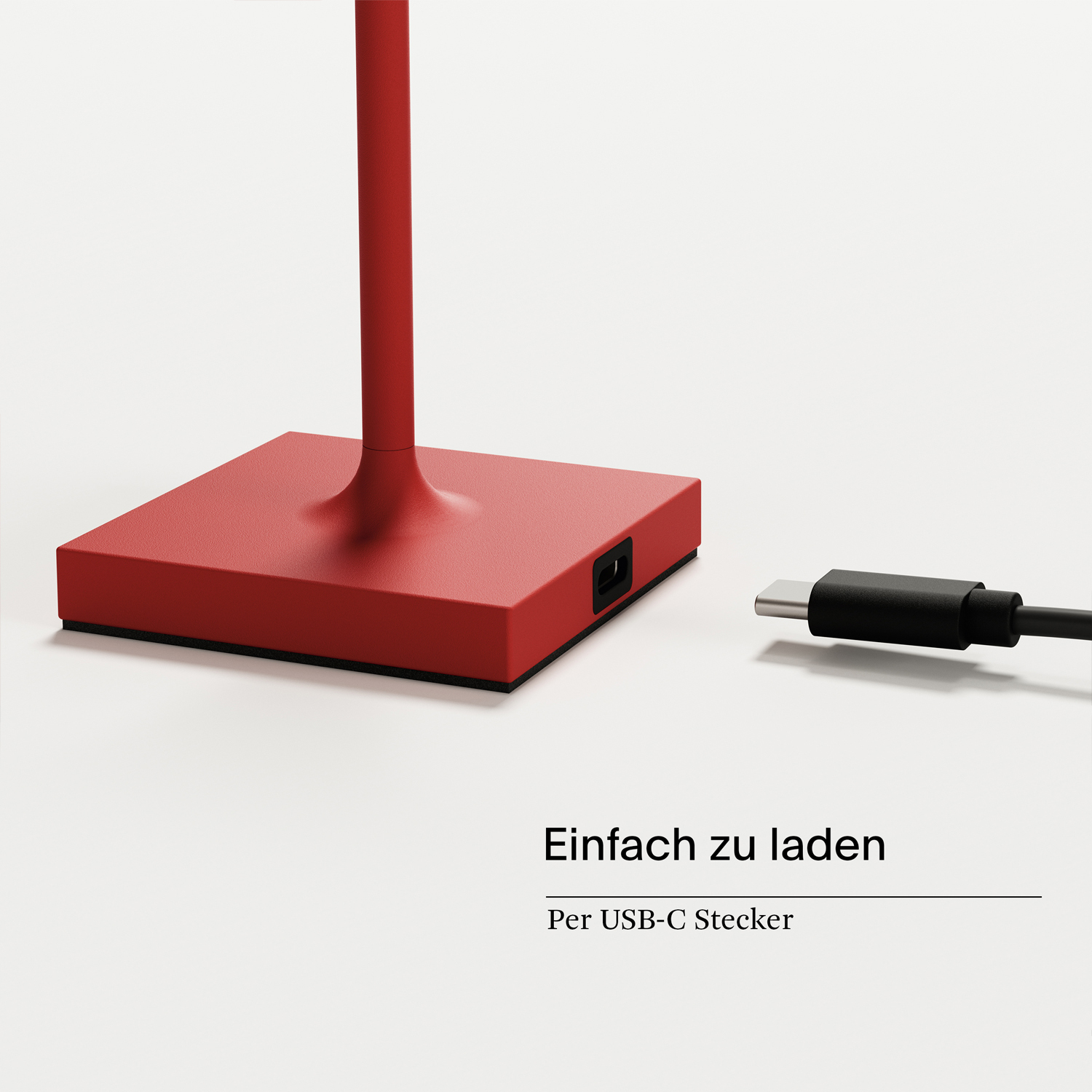 Roter Lampensockel mit Ladeanschluss und USB-Kabel auf weißem Hintergrund.