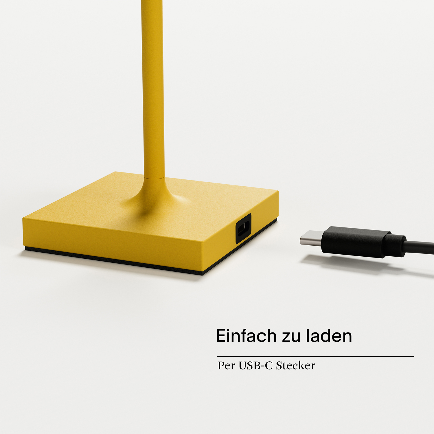 Gelber Lampensockel mit Ladeanschluss. Ein schwarzes Kabel ist eingesteckt. Weißer Hintergrund.
