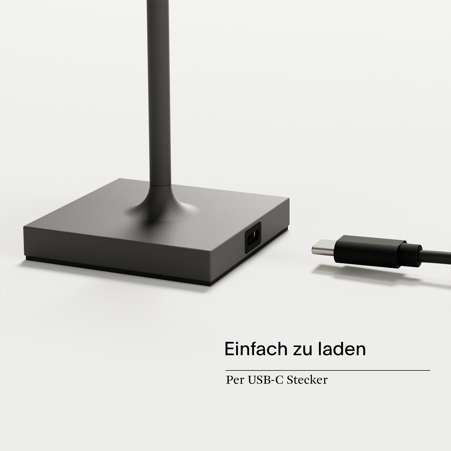 Ein schwarzer Lampensockel mit USB-C-Ladeanschluss. Daneben liegt ein Kabel.