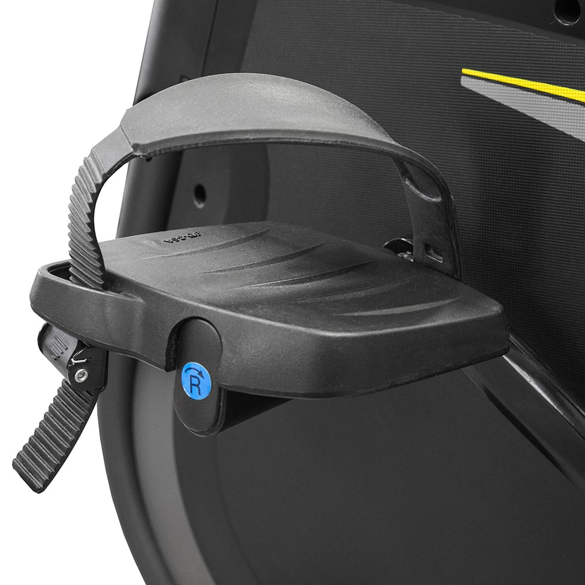 Close-up van een zwart pedaal van een hometrainer met een voetriem en een blauwe 'R' knop.