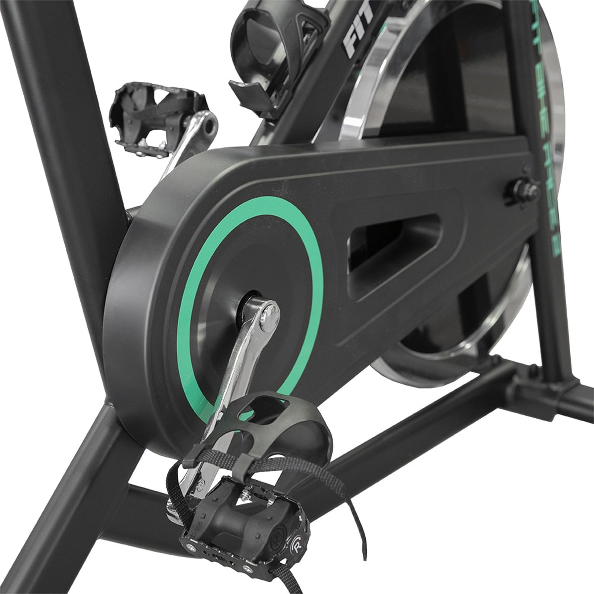 Black exercise bike with a green circle on the flywheel and pedal straps.