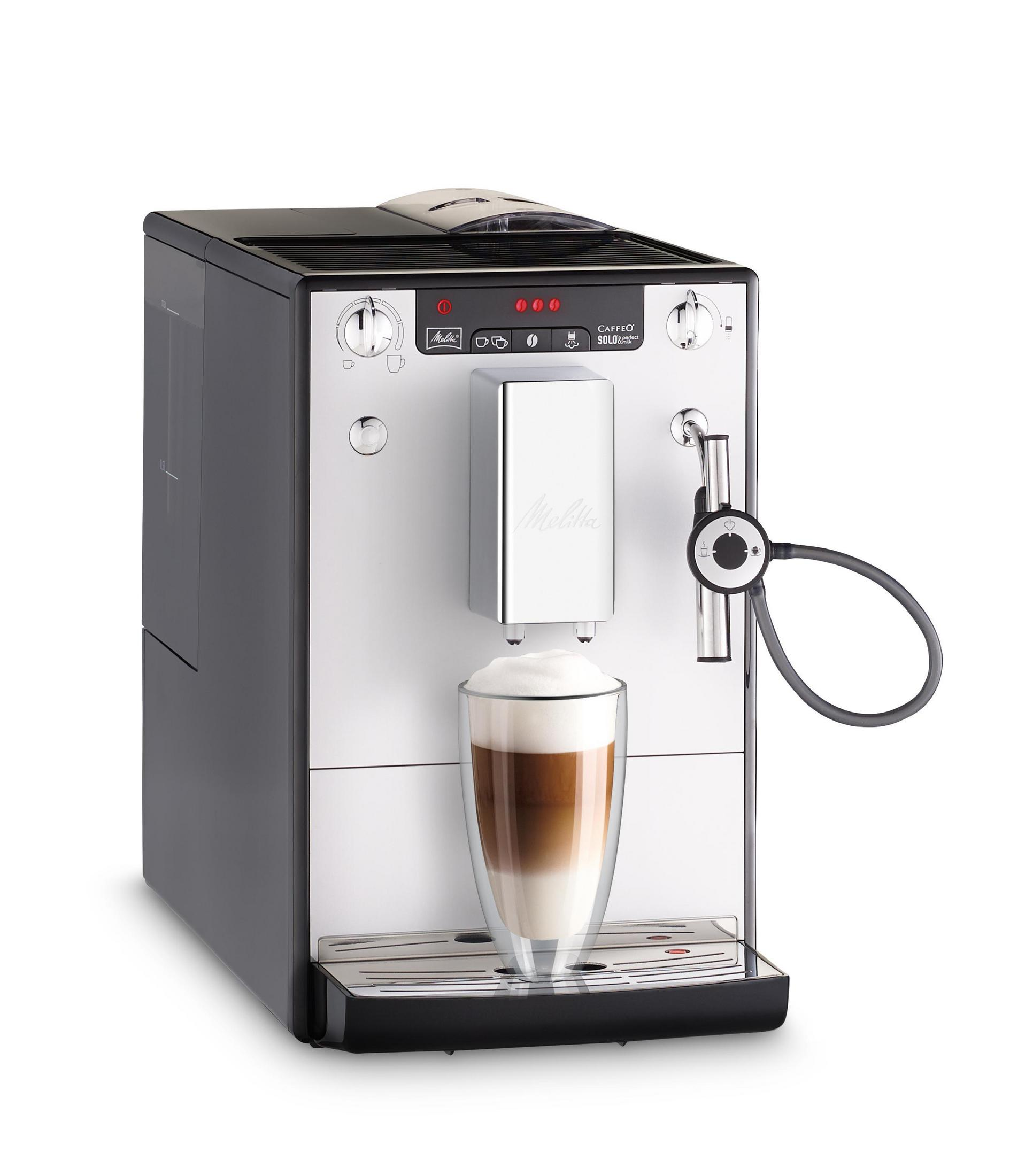 Eine silberne und schwarze Kaffeemaschine mit einem Glas Latte.