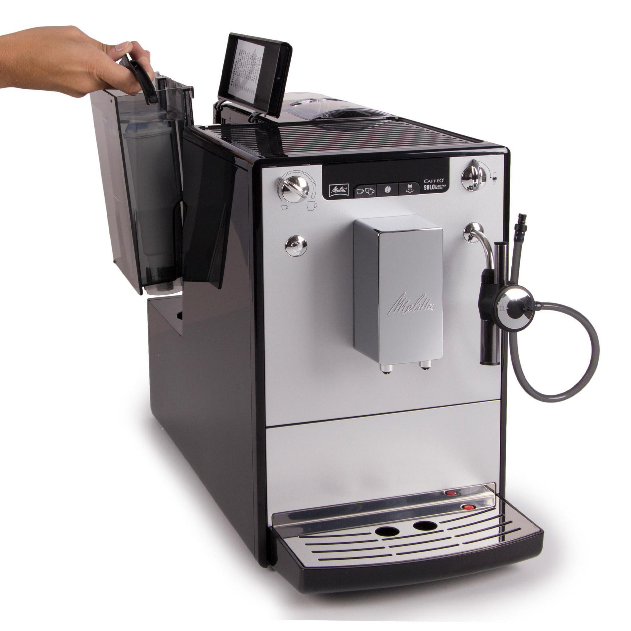 Kaffeemaschine in Silber und Schwarz. Eine Hand öffnet den Wasserbehälter an der Seite.
