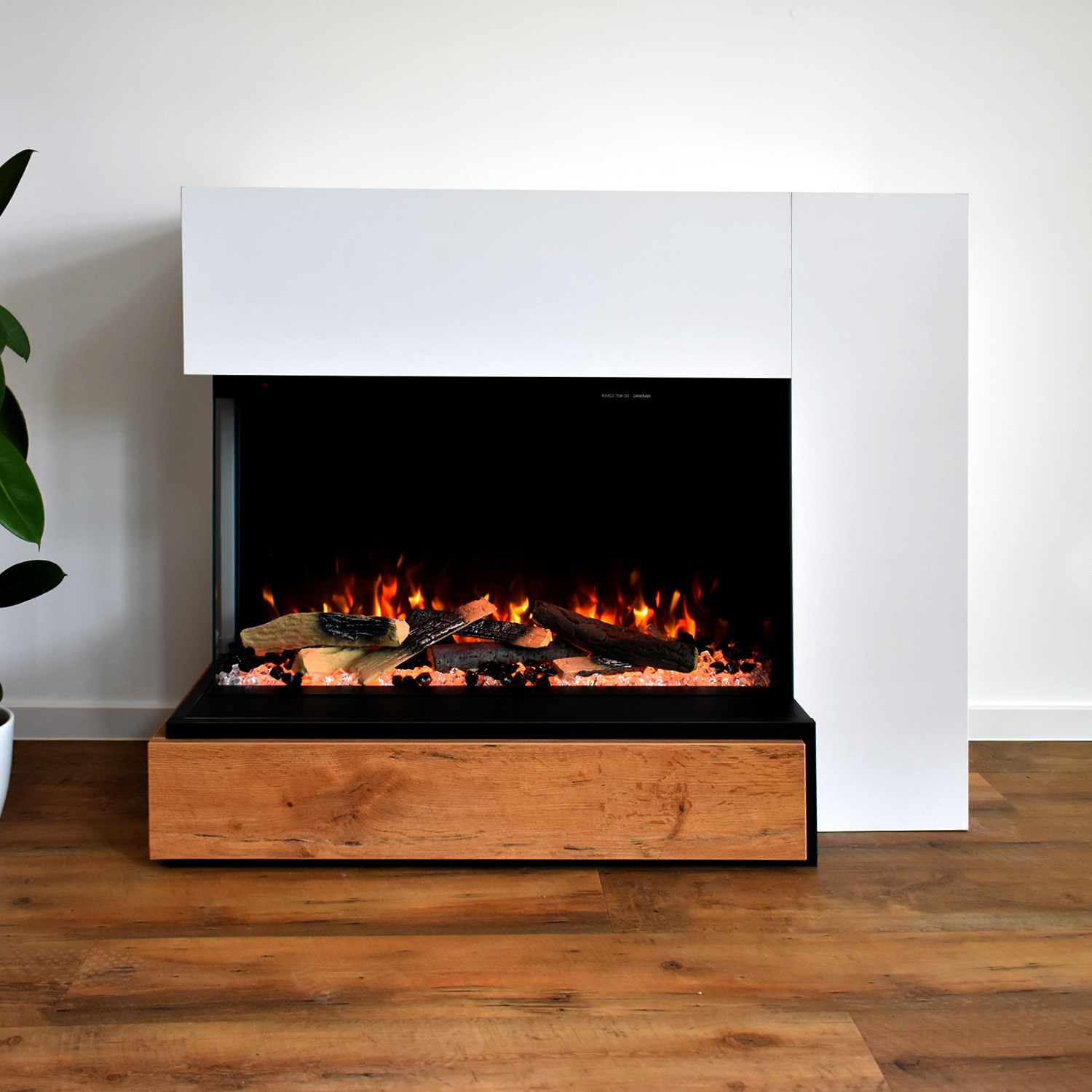 Ein weißer Kamin mit Flammen und Holz.