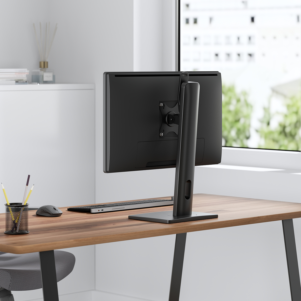 Computer-Monitorständer auf einem Holztisch, mit Tastatur und Maus. Weißer Hintergrund.