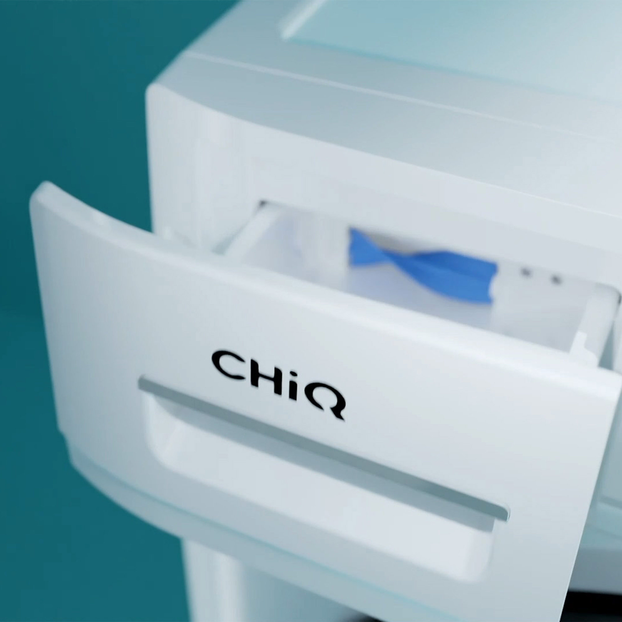 Nahaufnahme einer weißen Schublade mit dem Markennamen CHIQ. Im Inneren befindet sich ein blauer Gegenstand.