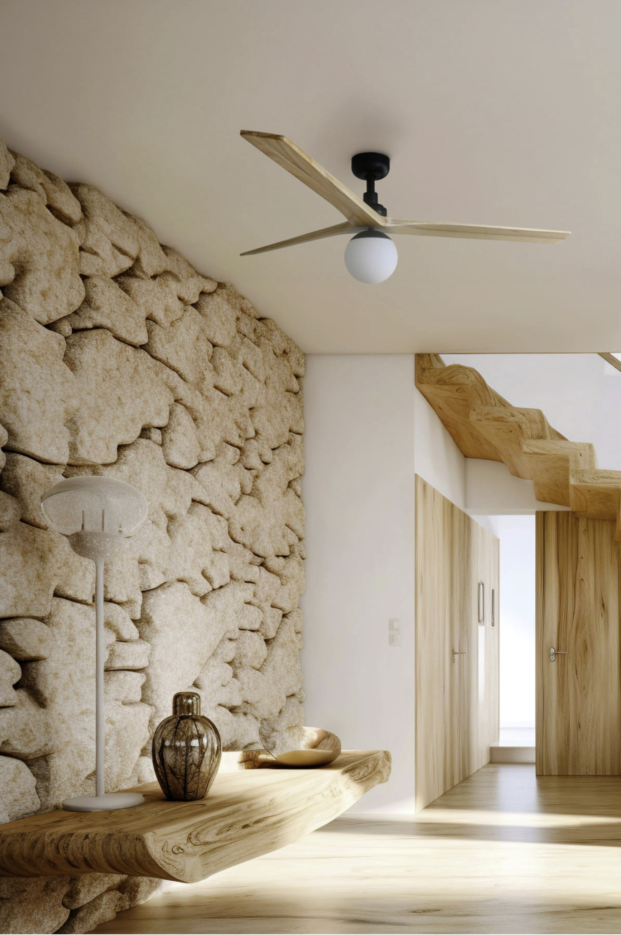 Innenraum mit Steinmauer, Deckenventilator aus Holz und einem Holztisch.