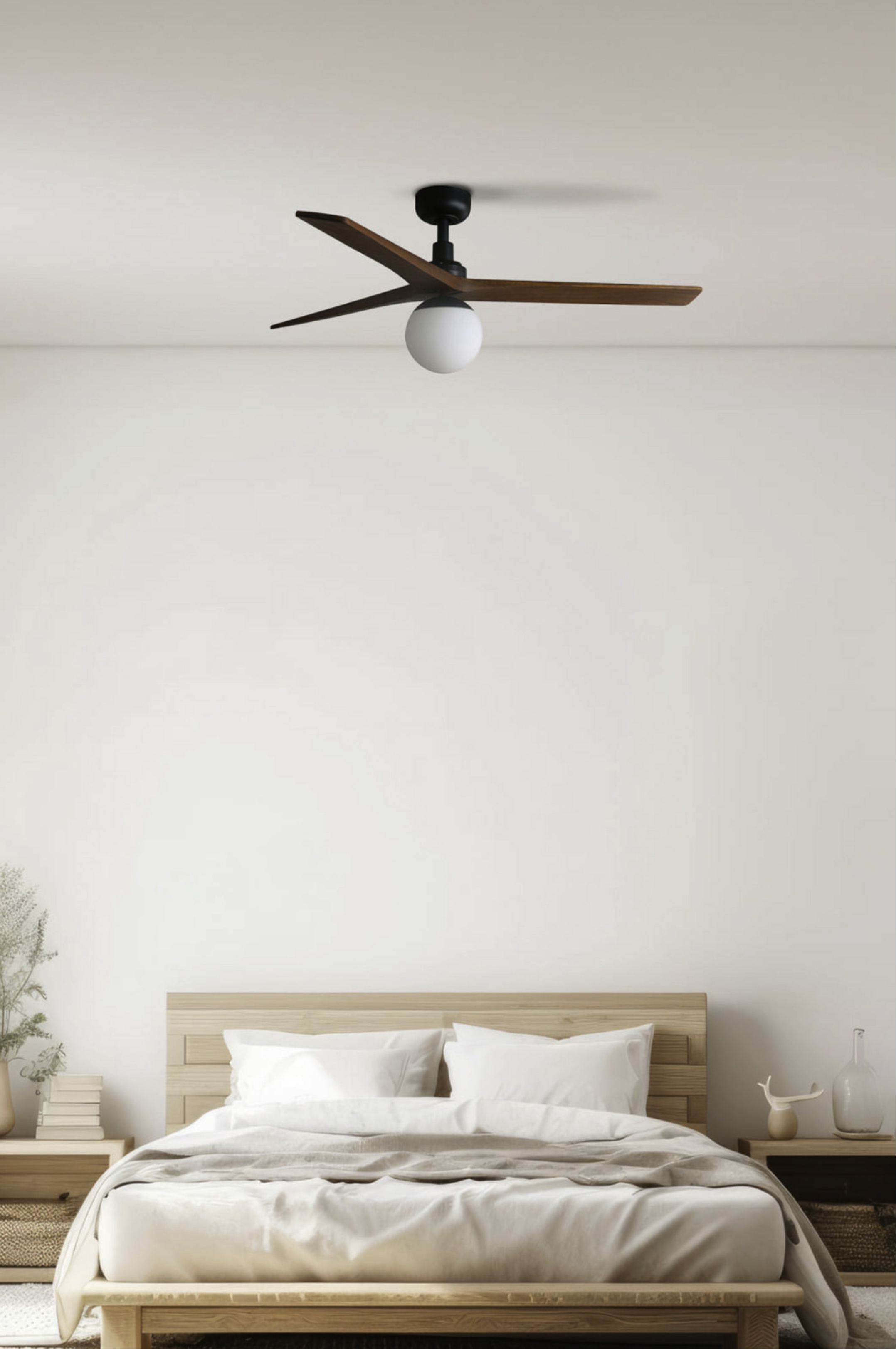 Schlafzimmer mit Bett und Deckenventilator. Der Ventilator hat braune Flügel. Die Wände sind weiß.