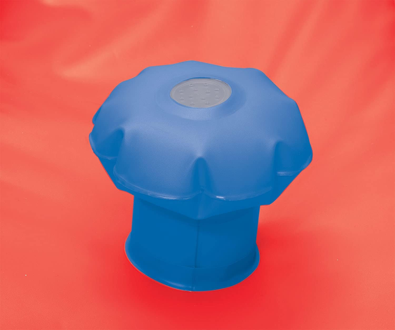Eine blaue Poolablaufabdeckung auf einer roten Oberfläche. Die Abdeckung ist rund und hat ein Muster.