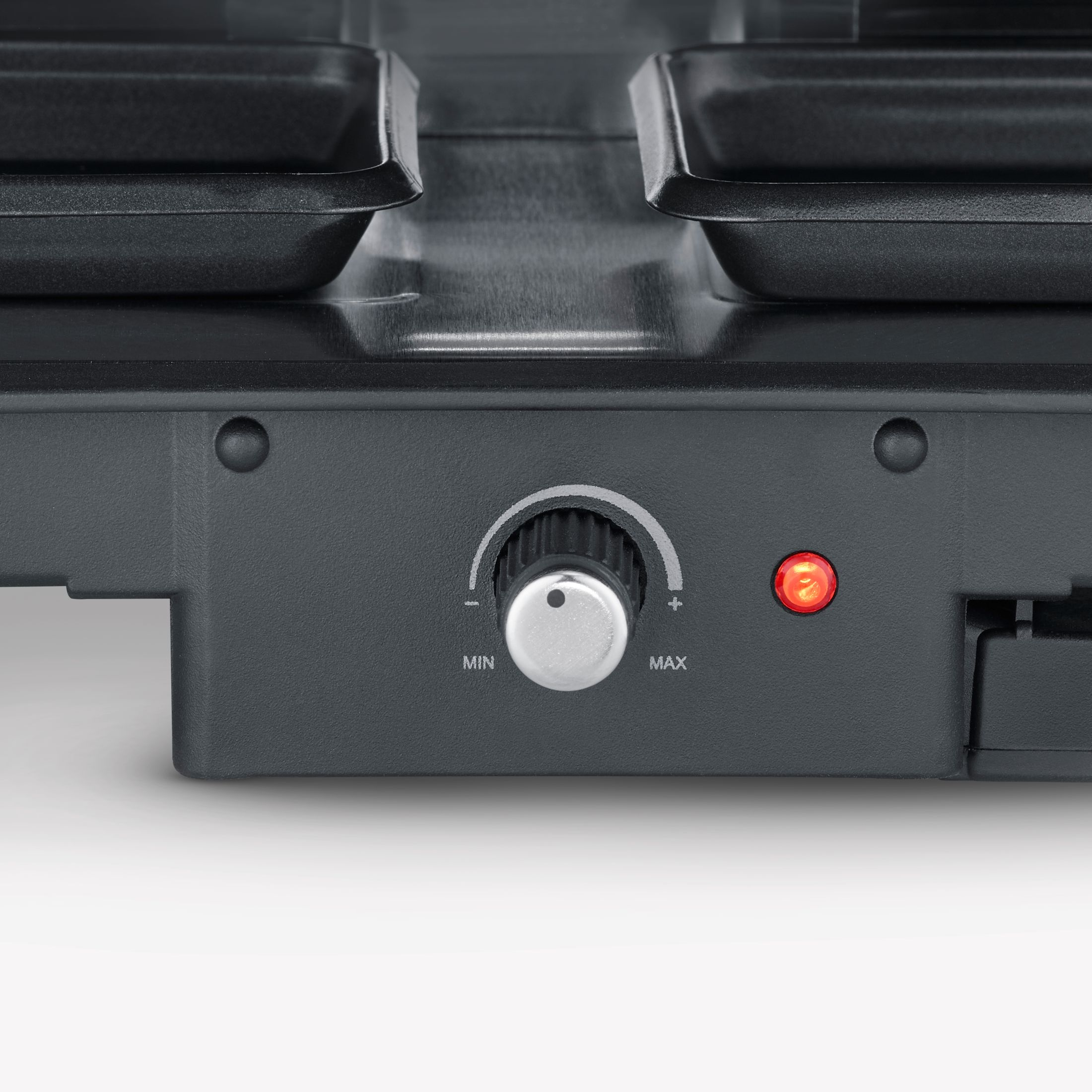 Zbliżenie na grill do raclette z pokrętłem i czerwonym światłem, na białym tle.