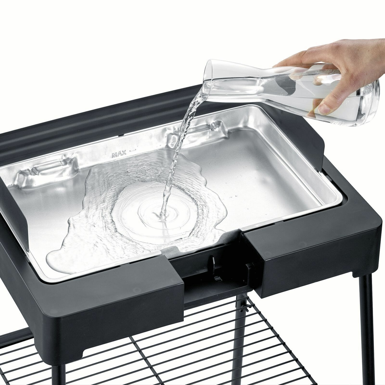 Water is being poured into a rectangular tray. The tray is part of a black grill on a stand.