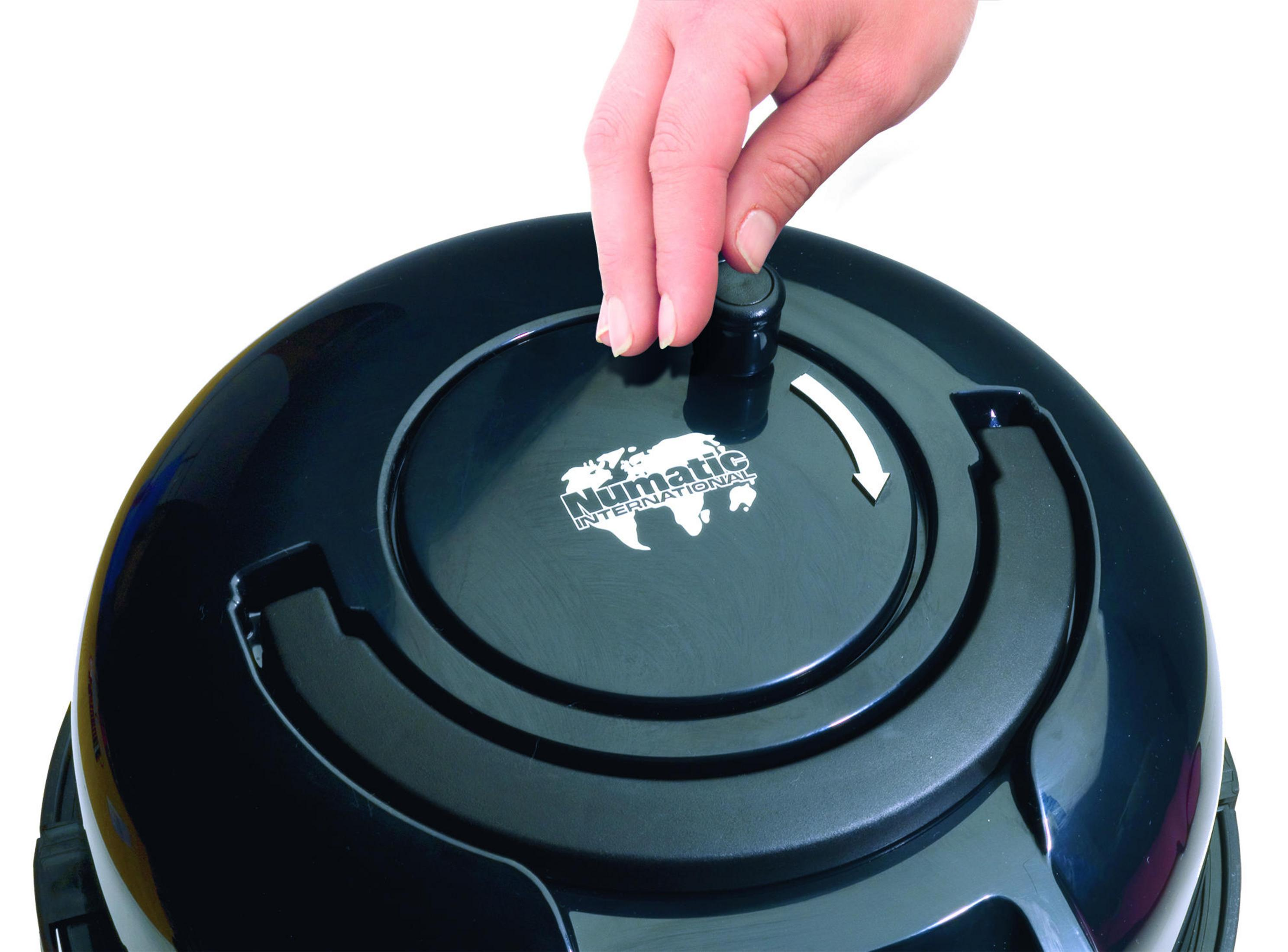 Ręka osoby obracająca pokrętło w czarnym odkurzaczu z marką 'Numatic International'.